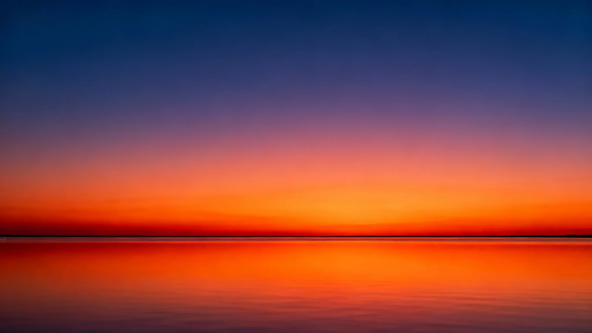 A beautiful, photorealistic image of a sunset over calm water, showcasing a perfectly smooth color gradient in the sky with no visible banding or artifacts.