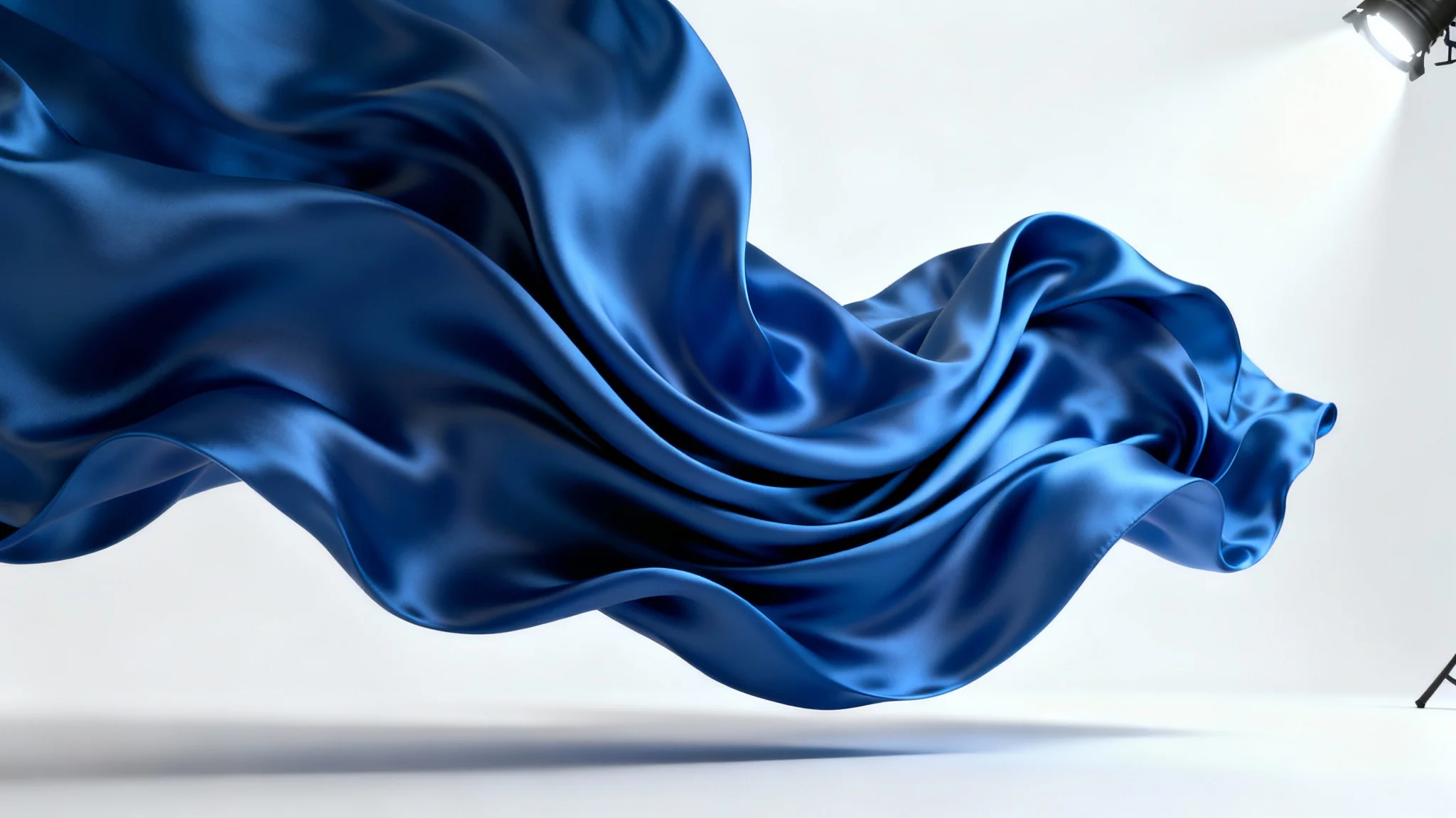 A photorealistic 3D rendering of a vibrant blue silk cloth suspended and frozen mid-swirl against a plain white background, showcasing realistic folds, textures, and lighting of a cloth simulation.