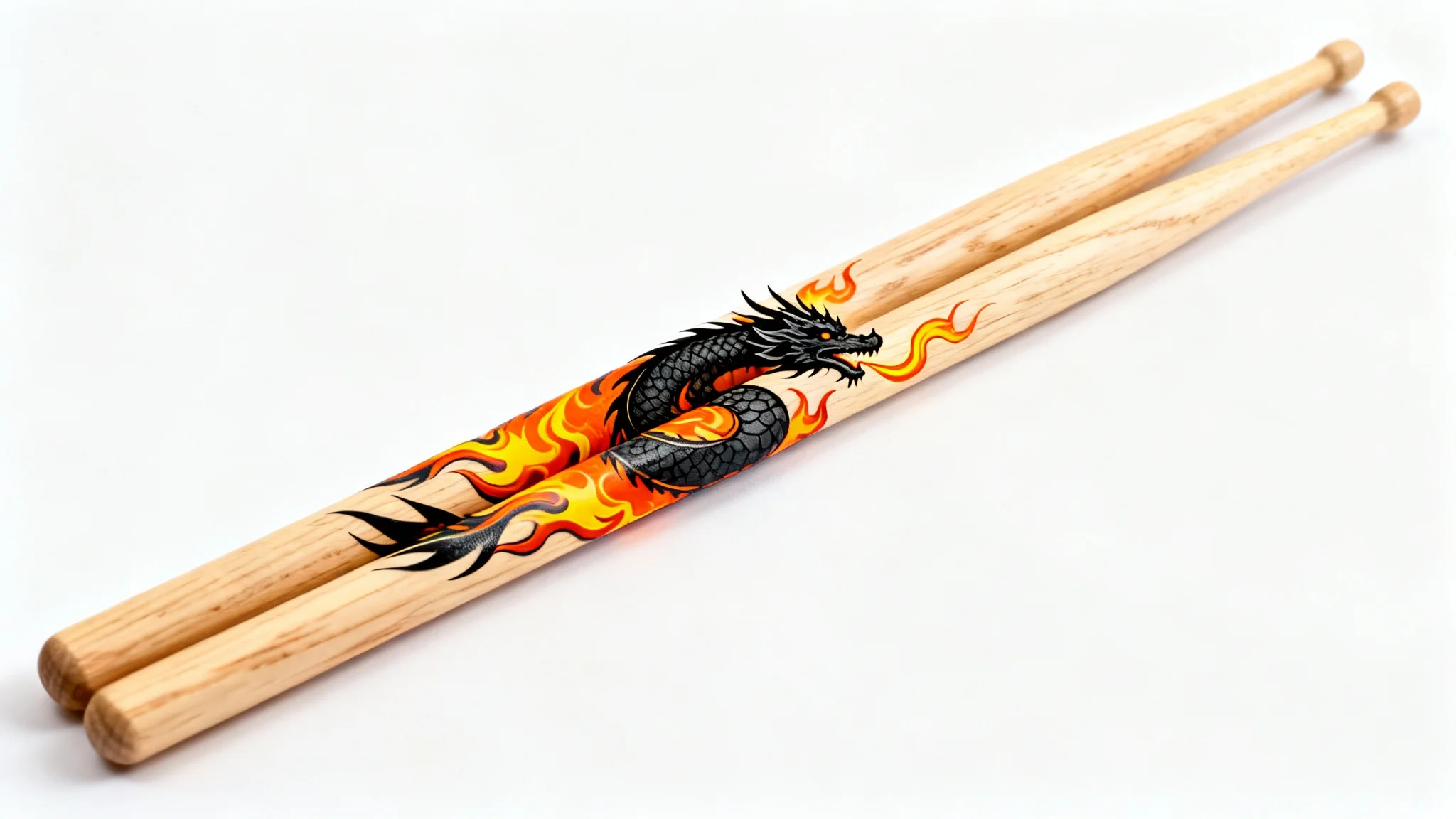 A pair of custom-designed maple drumsticks with a detailed black dragon breathing fire design, displayed on a clean white background.