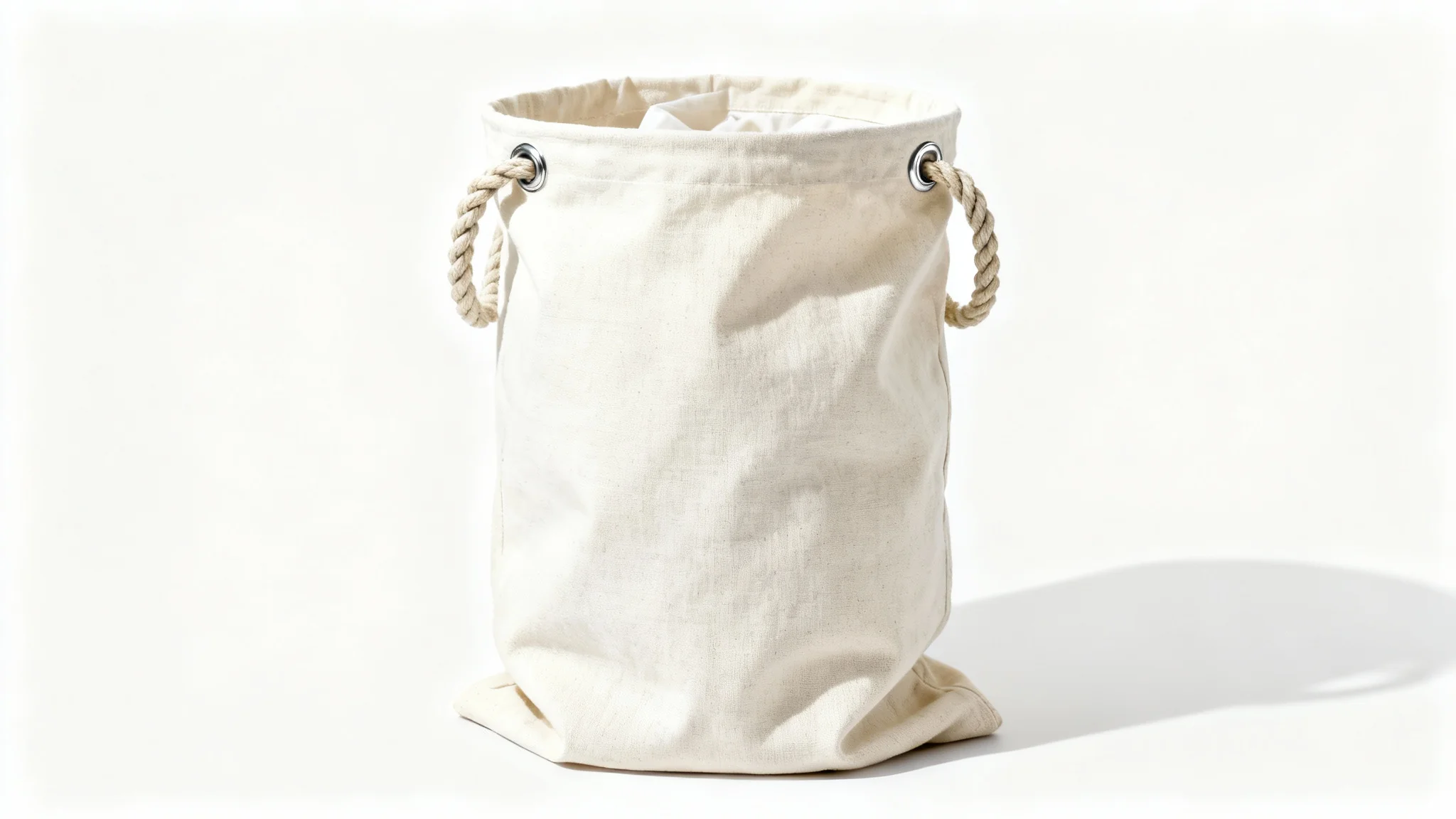 A photorealistic mockup of a modern, off-white canvas laundry bag with a thick rope drawstring, standing upright against a clean white background.