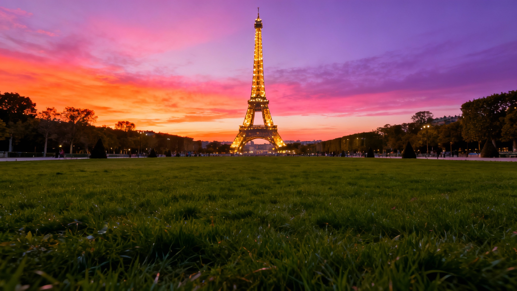 A stunning, high-resolution photo of the Eiffel Tower at sunset, its lights twinkling against a vibrant pink and orange sky, ideal for a digital background.