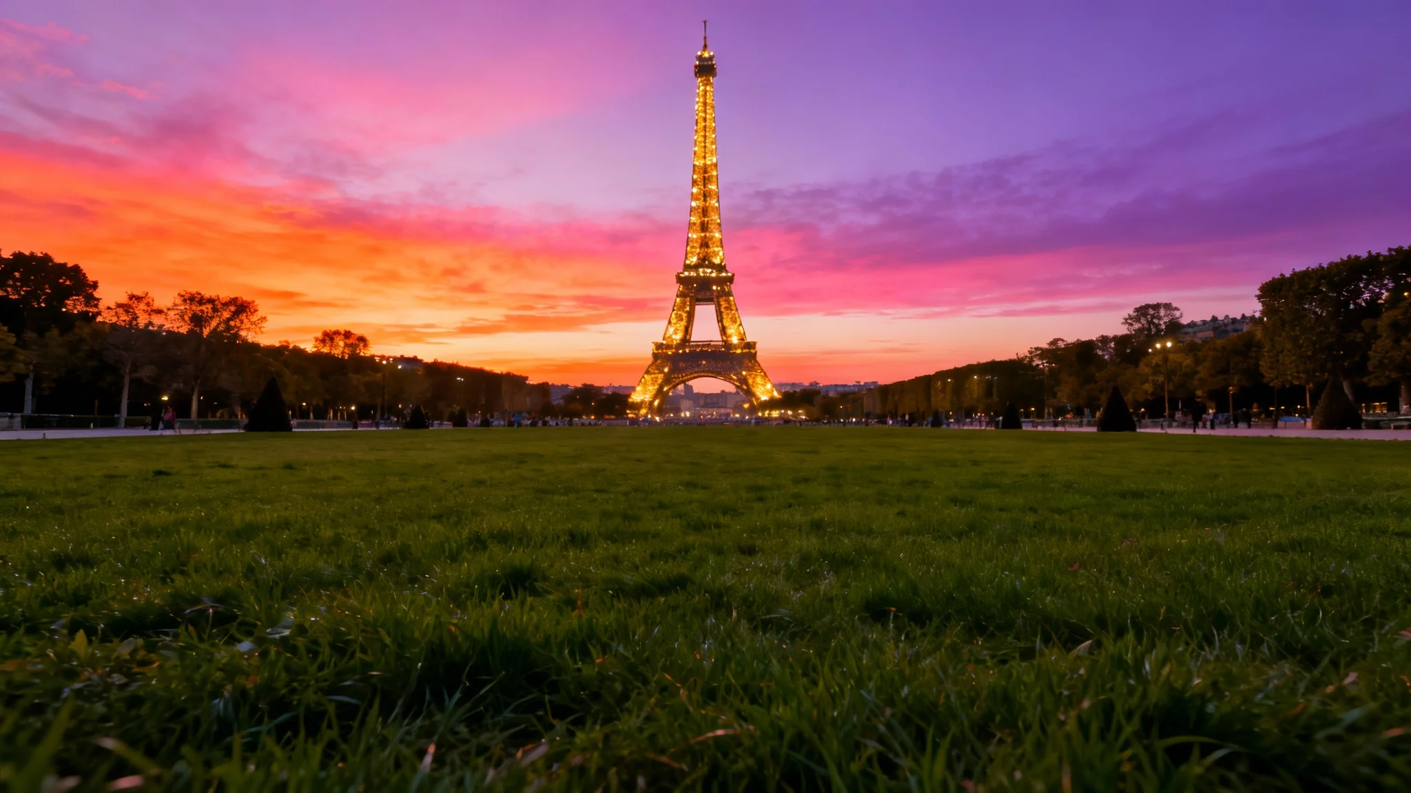 A stunning, high-resolution photo of the Eiffel Tower at sunset, its lights twinkling against a vibrant pink and orange sky, ideal for a digital background.