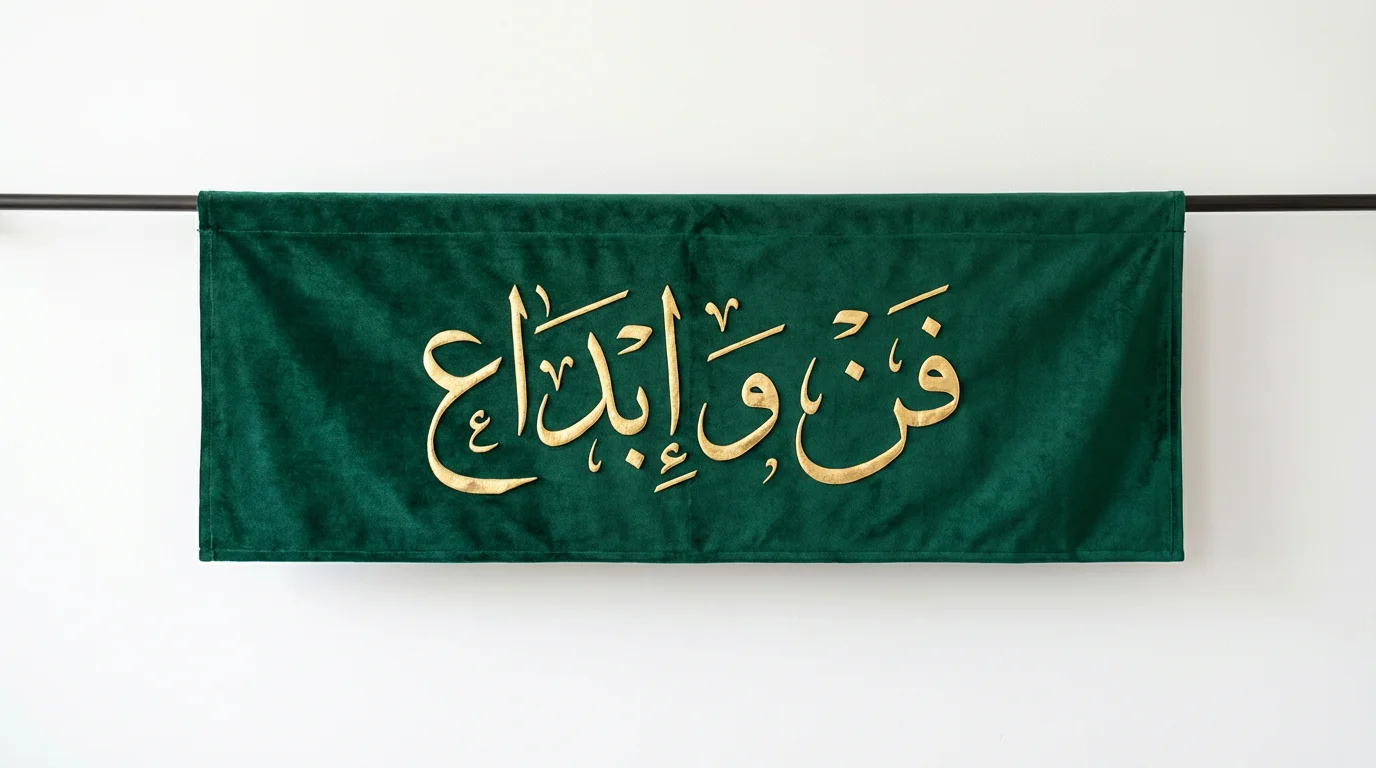 A professional mockup of a luxurious emerald green banner featuring the Arabic calligraphy phrase 'Art and Creativity' in gleaming gold, set against a clean white background.