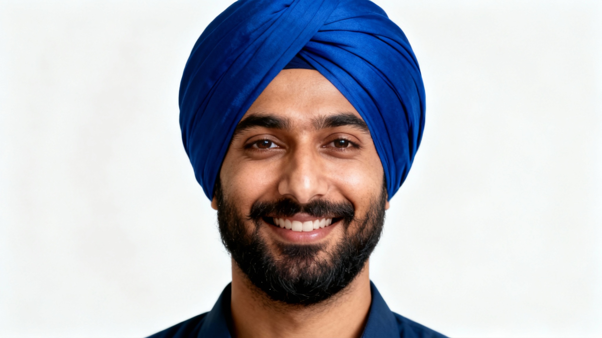 A photorealistic portrait of a smiling South Asian man with a beard wearing a vibrant royal blue turban, set against a clean white background.