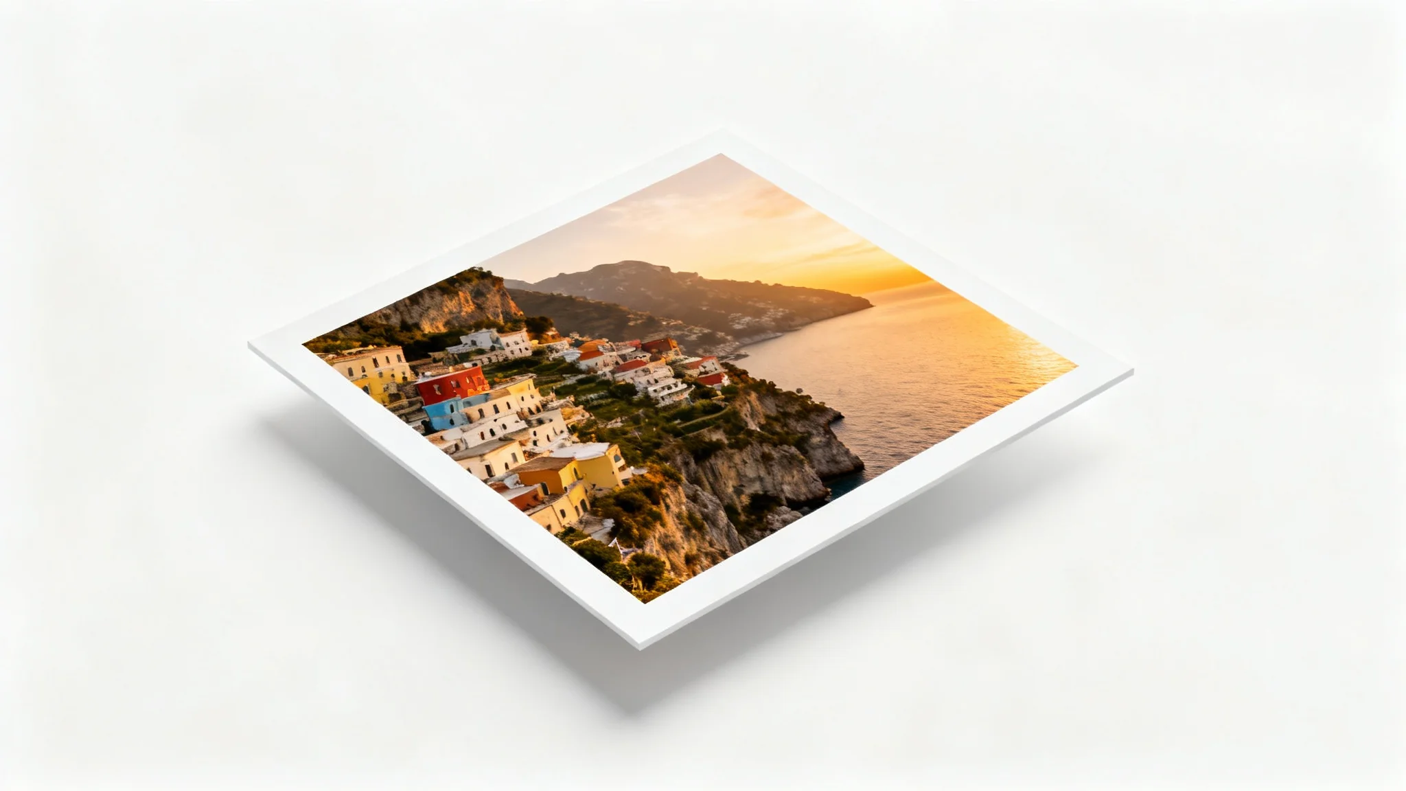 A high-quality photograph of the Amalfi Coast at sunset, framed with a prominent, clean white border, presented as a mockup on a plain white background.