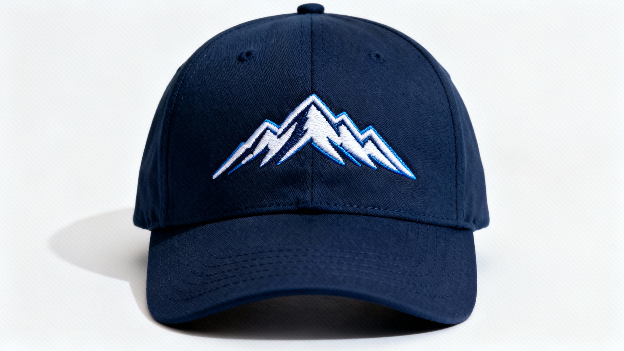 A professional mockup of a dark navy blue baseball cap on a white background, featuring a detailed, high-quality embroidery of a stylized white and blue mountain range on the front.