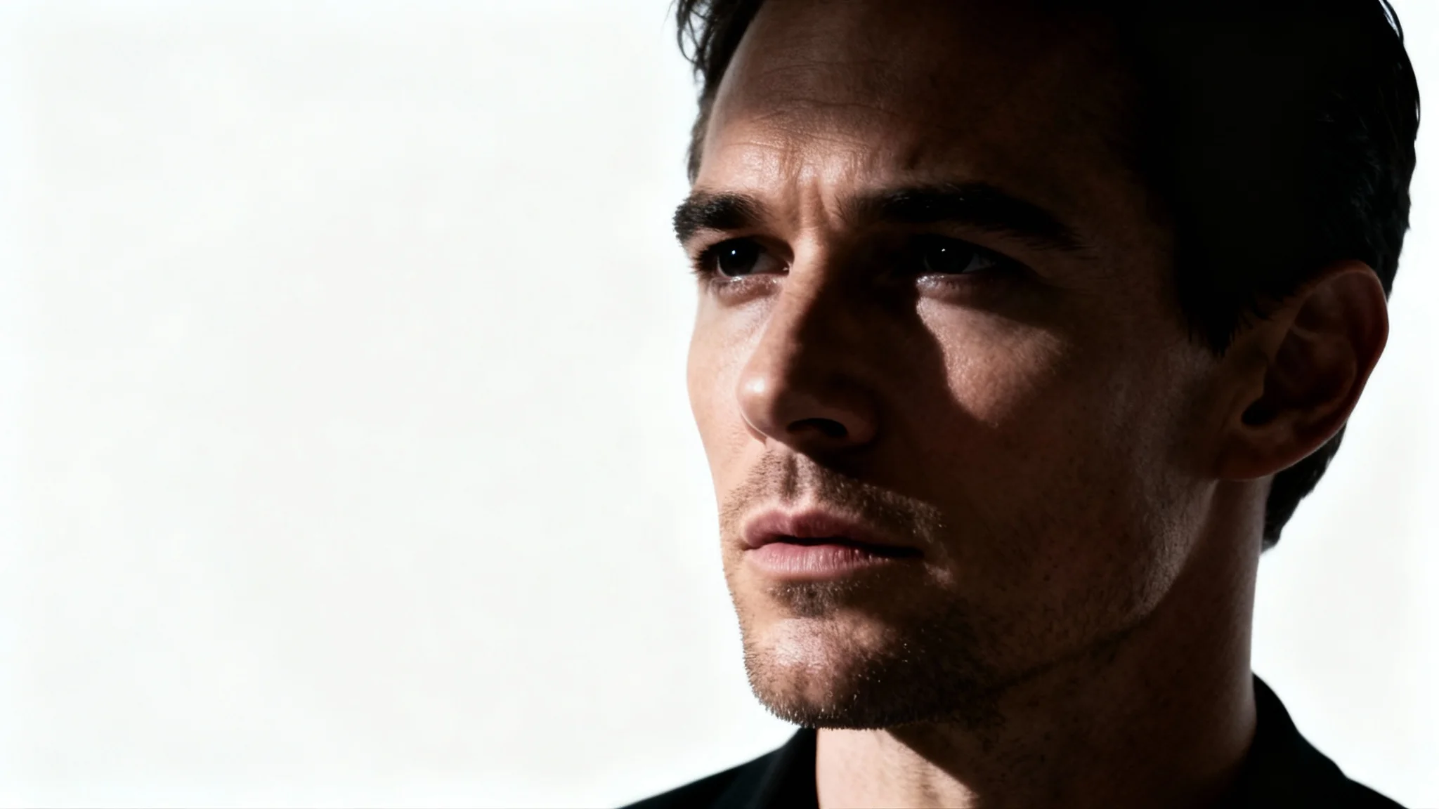 A highly realistic, cinematic portrait of a man with dramatic lighting that creates deep shadows on his face, giving him a thoughtful and intense expression, isolated on a white background.