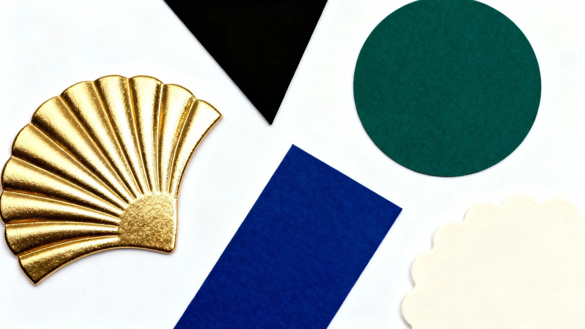 A top-down view of color swatches in Art Deco shapes representing a roaring twenties color palette, including gold, black, emerald, sapphire, and ivory on a white background.