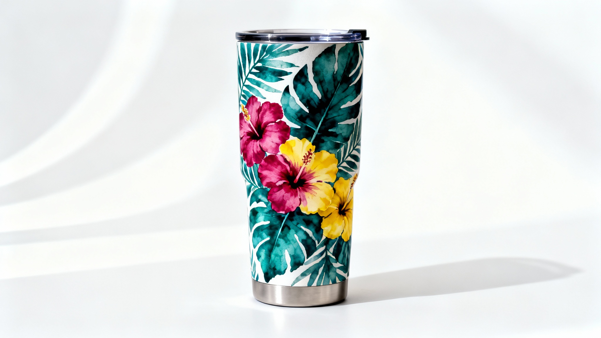 A modern stainless steel tumbler with a vibrant tropical floral and leaf wrap design, shown in a professional product shot against a plain white background.