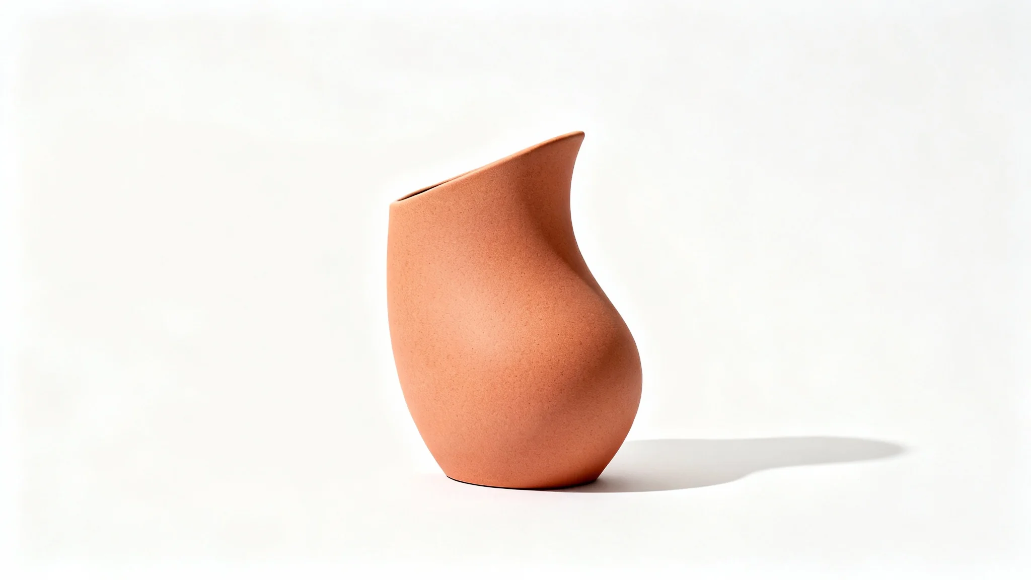 A modern ceramic vase with a matte terracotta finish, displayed in a studio setting on a pure white background.