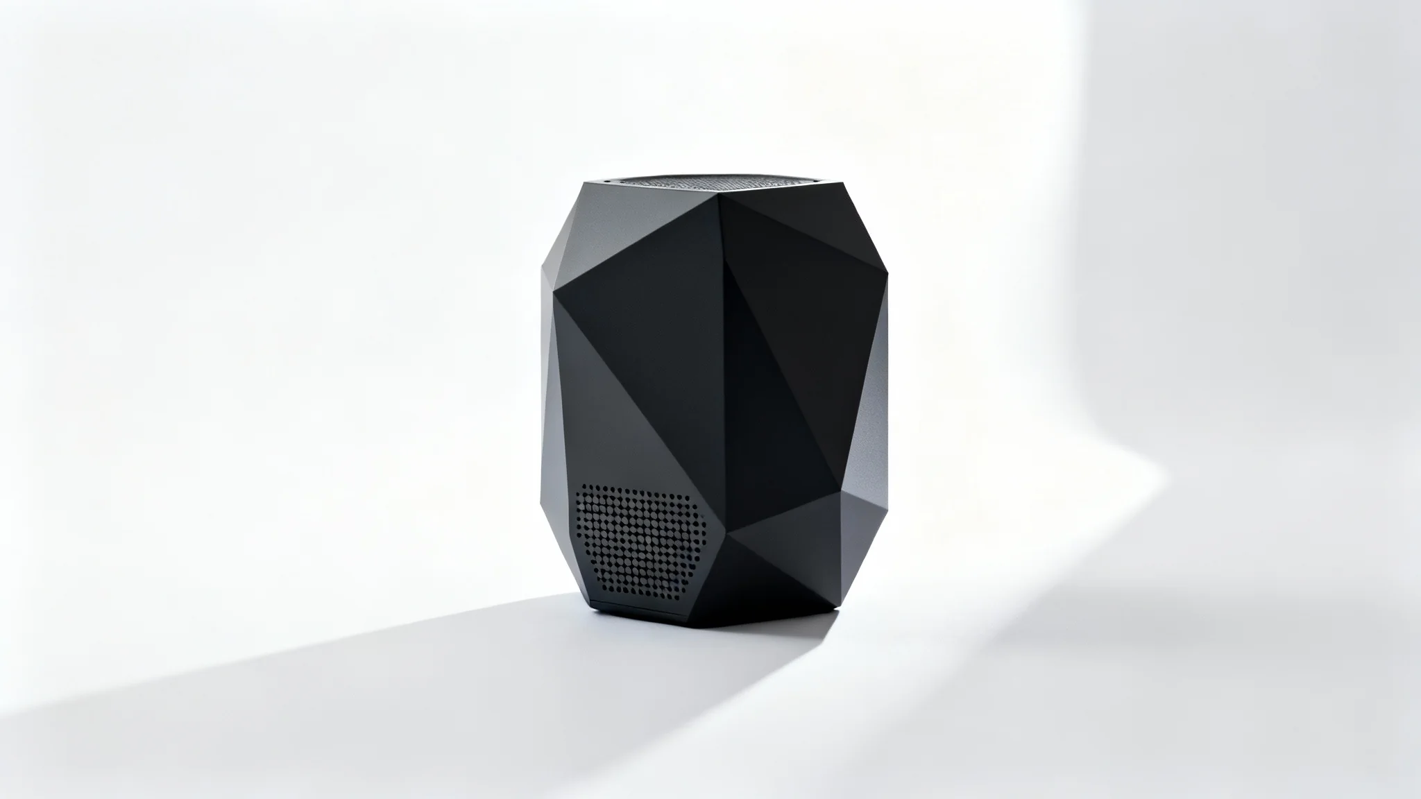 A photorealistic mockup of a modern, matte black wireless speaker with a geometric design, shown against a plain white background to emphasize its form.