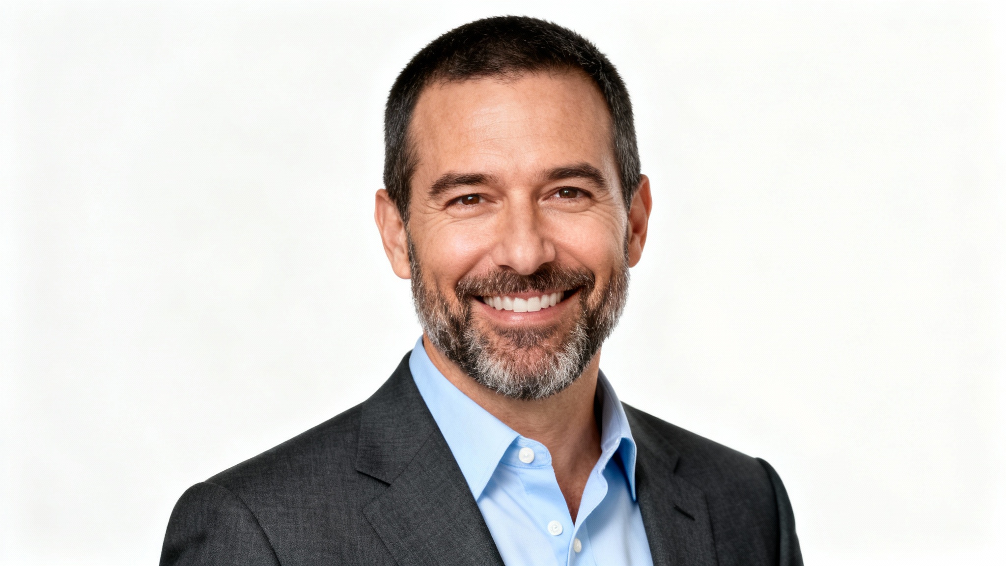 A professional, studio-quality headshot of a smiling man in a suit, looking confident and ready for business, set against a solid white background.
