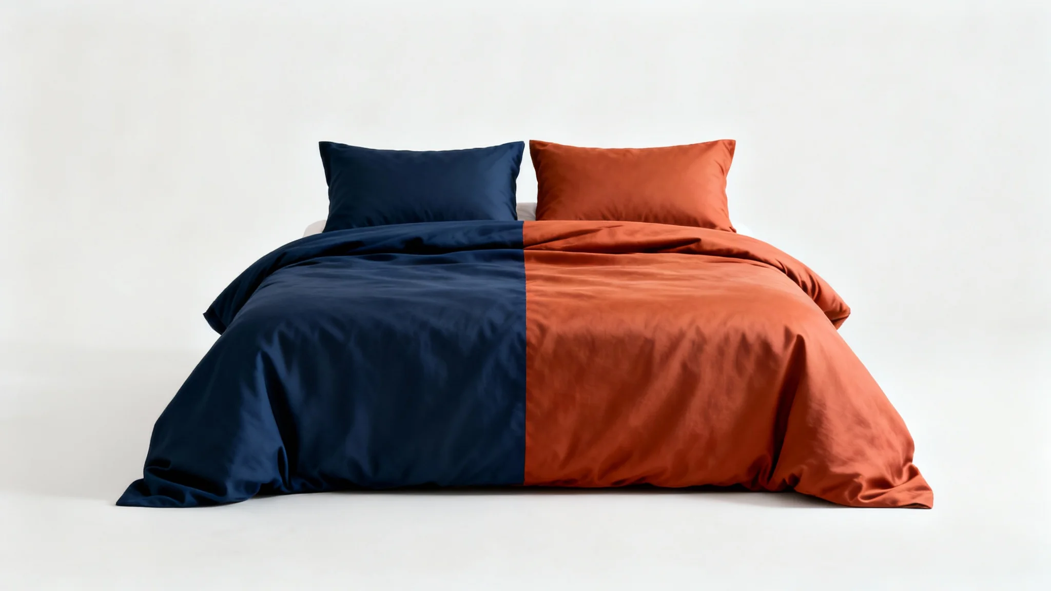 A minimalist product shot of a bed with a duvet that is changing color from navy blue to terracotta orange, set against a clean white background.