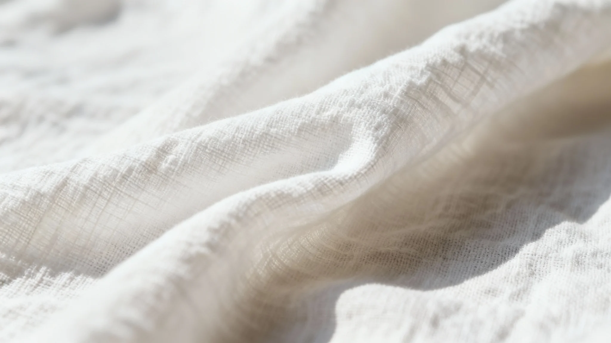 An eye-catching hero image showing a detailed macro shot of natural white cotton fabric, with soft drapes and lighting that highlights the texture of the weave.