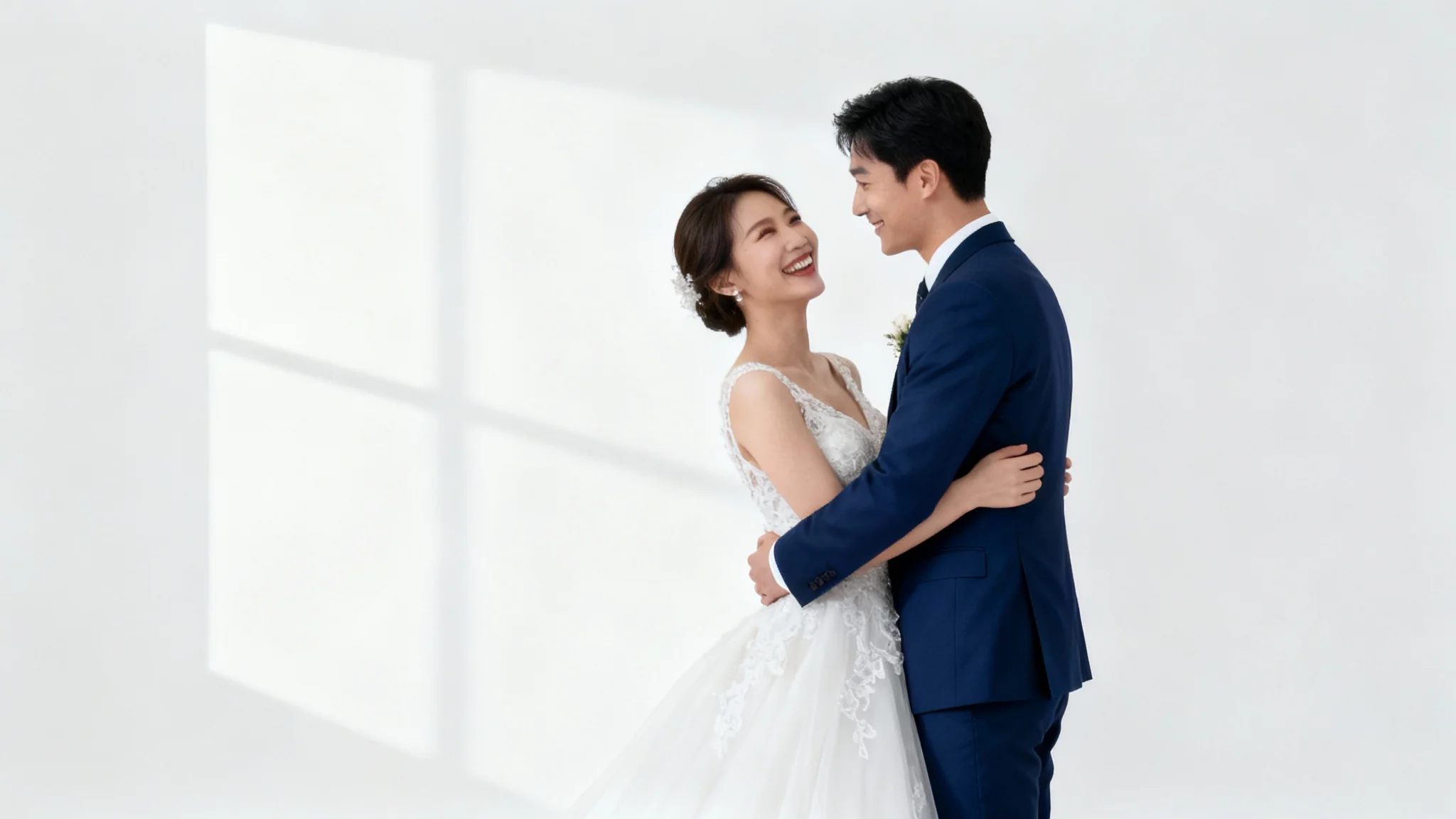 A professional mockup of a wedding photo showing a happy newlywed couple embracing against a plain white background. The bride is in a white lace dress and the groom is in a navy suit.