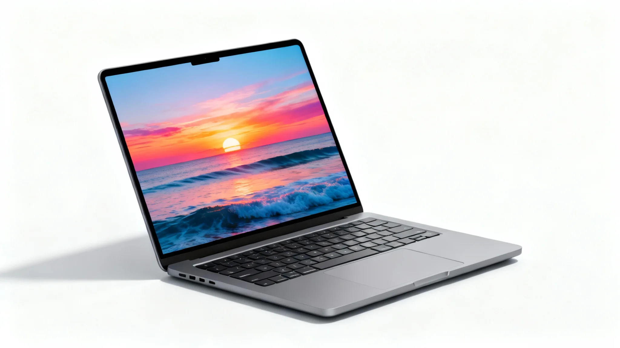 A modern space gray laptop is angled on a white background, its screen displaying a vibrant image of a sunset over the ocean.