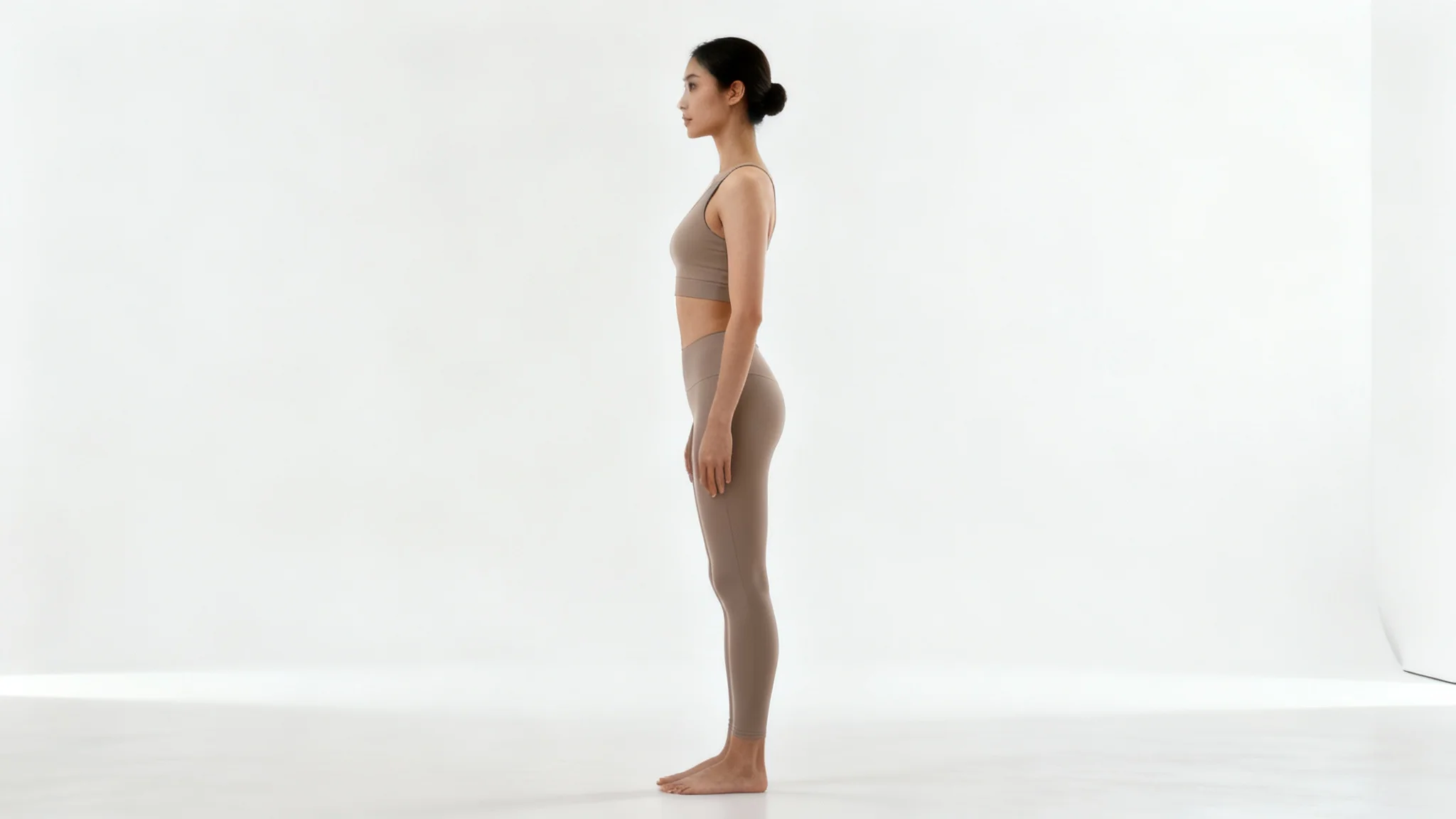 A full-body side view of a person standing with perfect posture, showcasing a straight spine and aligned shoulders against a clean white background.