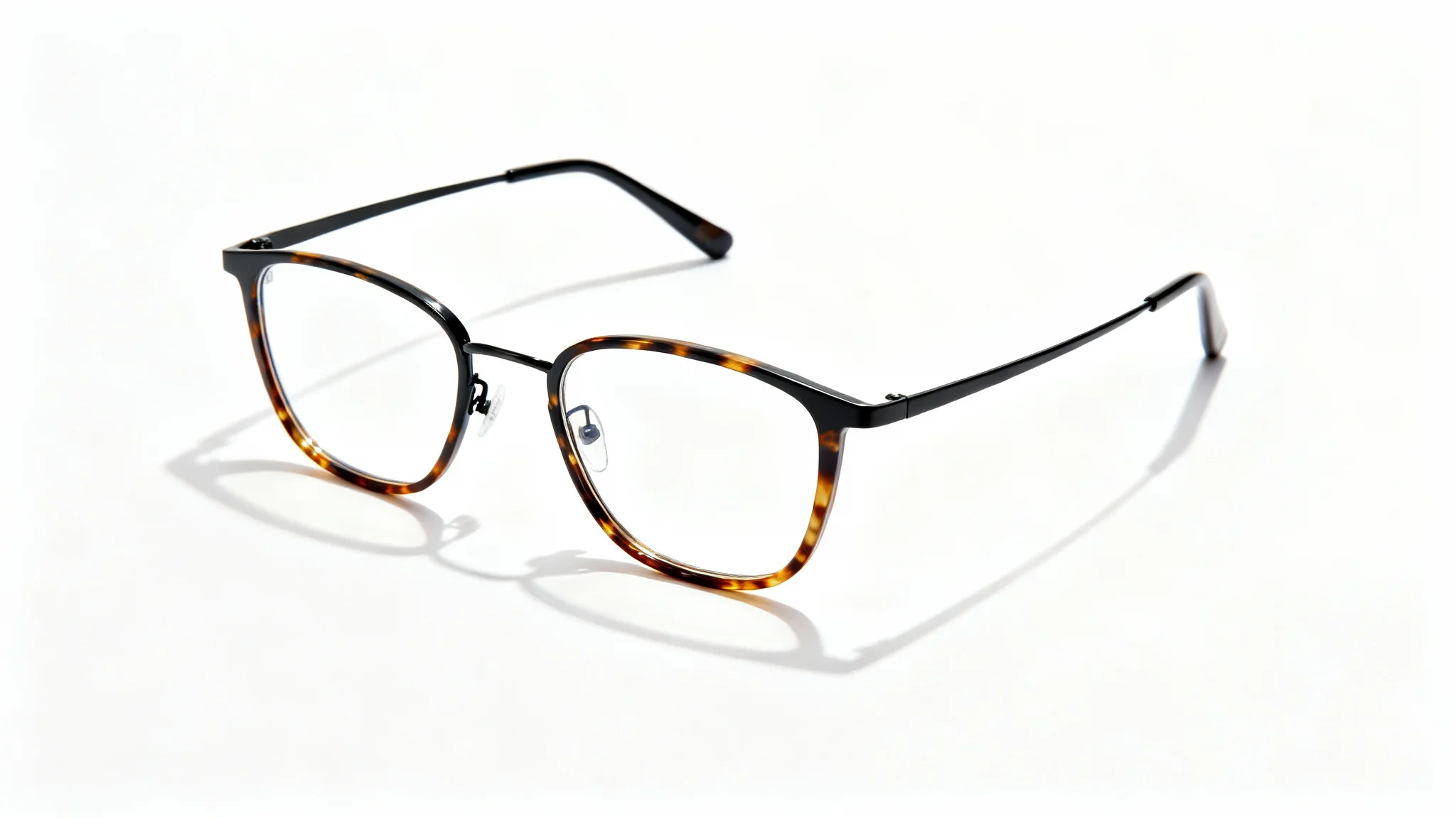 A photorealistic mockup of a pair of modern eyeglasses with a matte black metal and tortoiseshell frame, displayed on a clean white background.