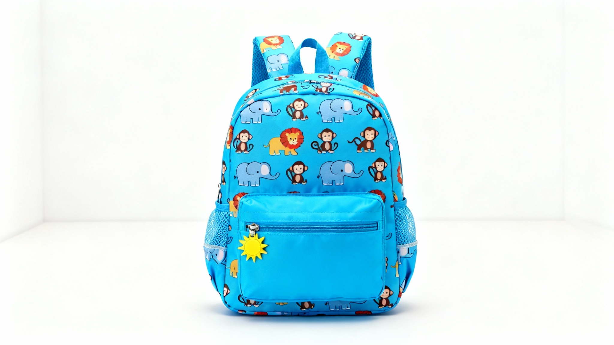A professional product shot of a kids' backpack mockup featuring a fun cartoon animal print with elephants, lions, and monkeys on a blue background, set against a clean, neutral backdrop.
