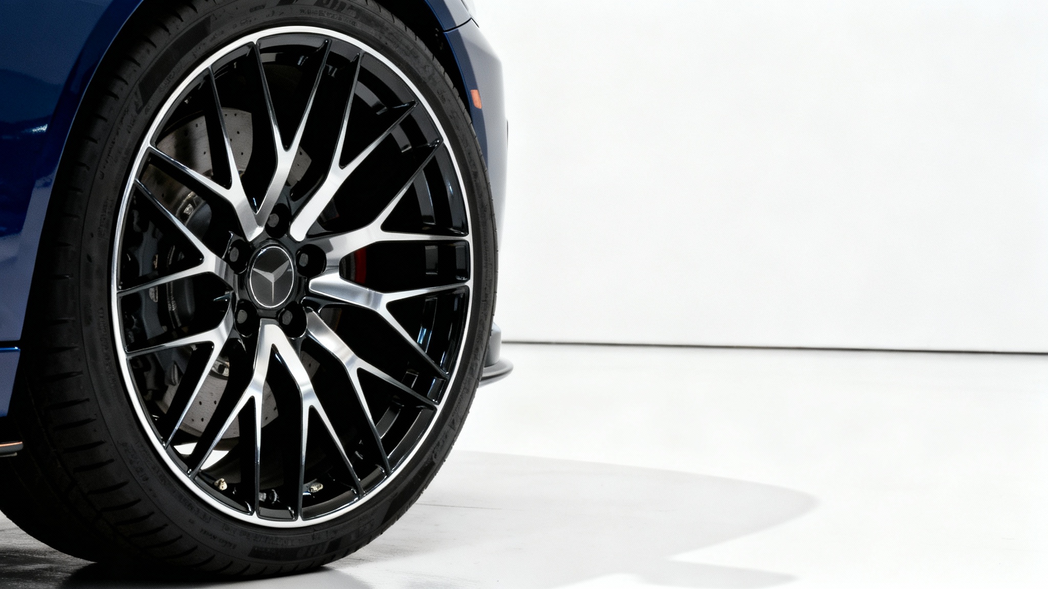 A hyper-realistic studio shot of a high-performance, multi-spoke car rim in black and silver, mounted on a tire against a stark white background.