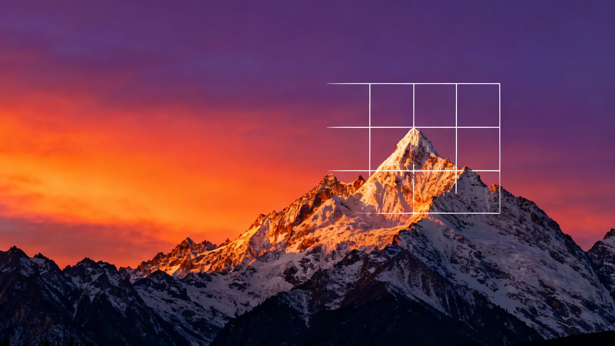A beautiful mountain landscape at sunset with a semi-transparent 3x3 grid overlay, demonstrating a compositional tool.