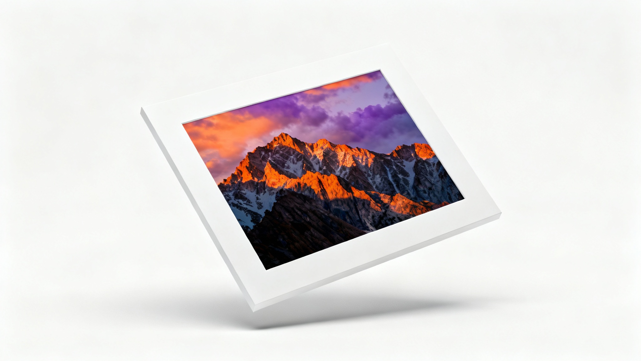 A photorealistic mockup of a landscape photograph of a mountain sunset, framed with a thick white border and displayed against a clean white background.