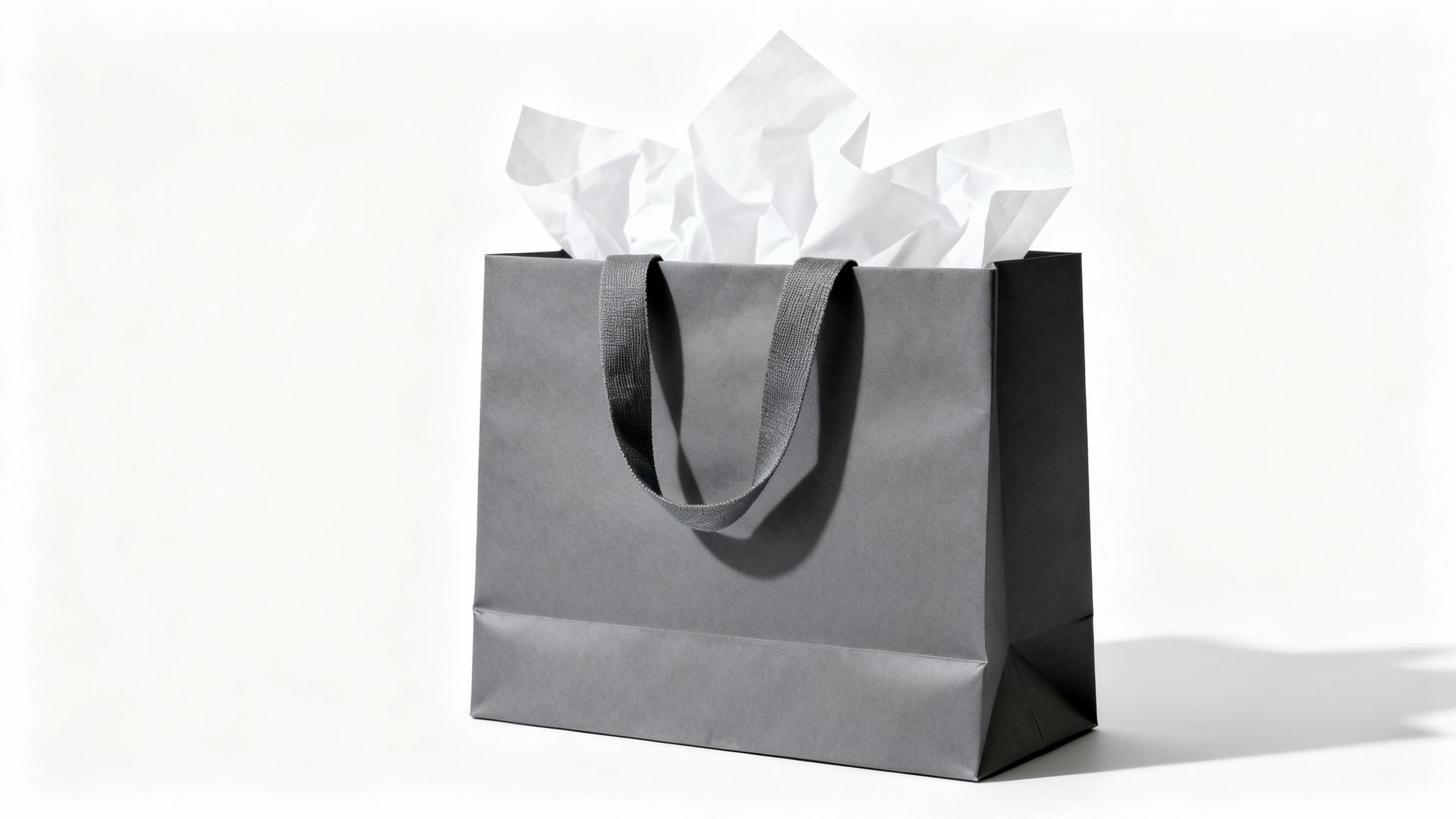 A slate gray premium shopping bag with white tissue paper peeking out, symbolizing a confirmed order, on a clean white background.