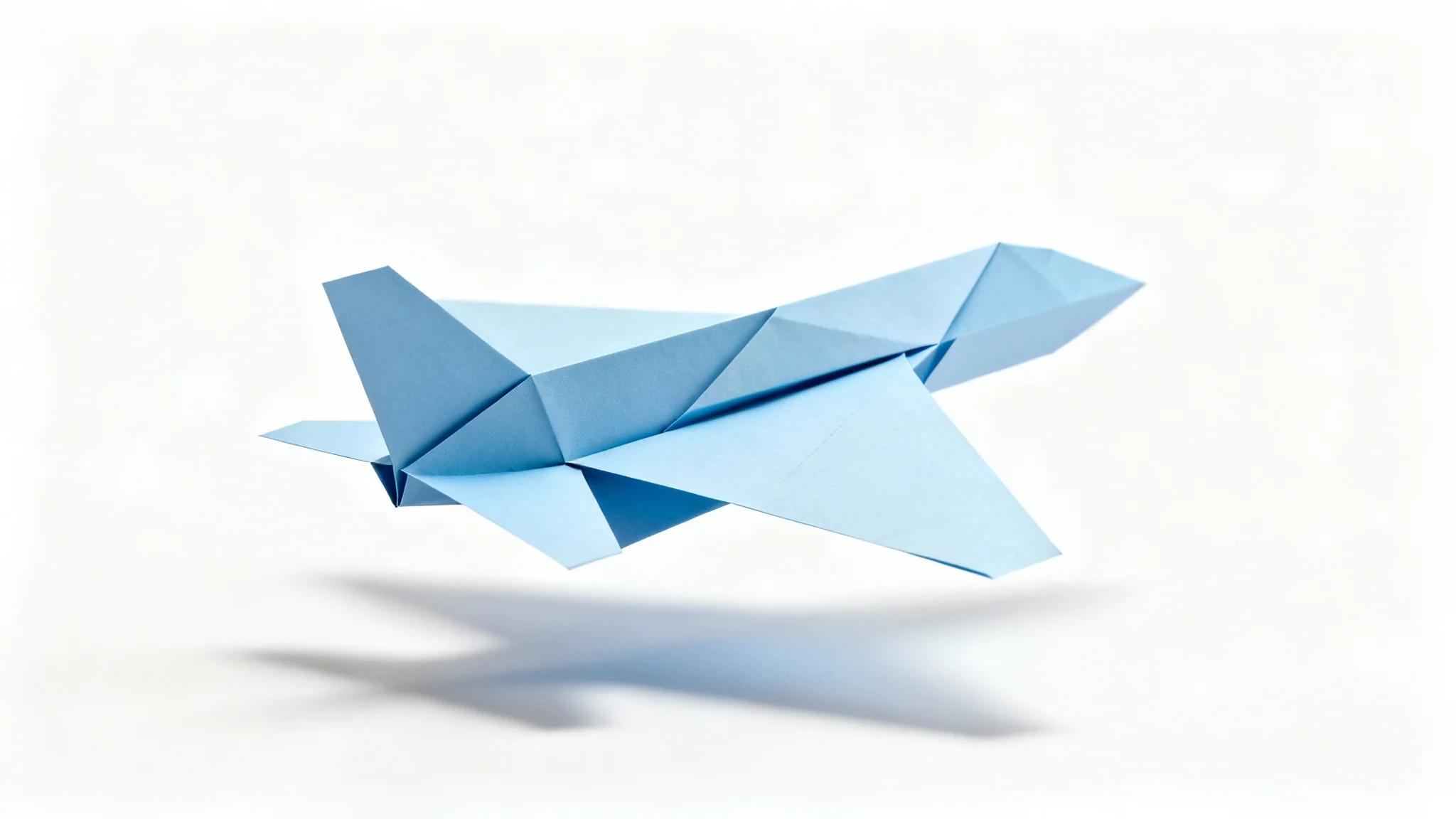 A photorealistic mockup of a light blue paper cutout of a commercial airplane, floating against a solid white background with a soft shadow.
