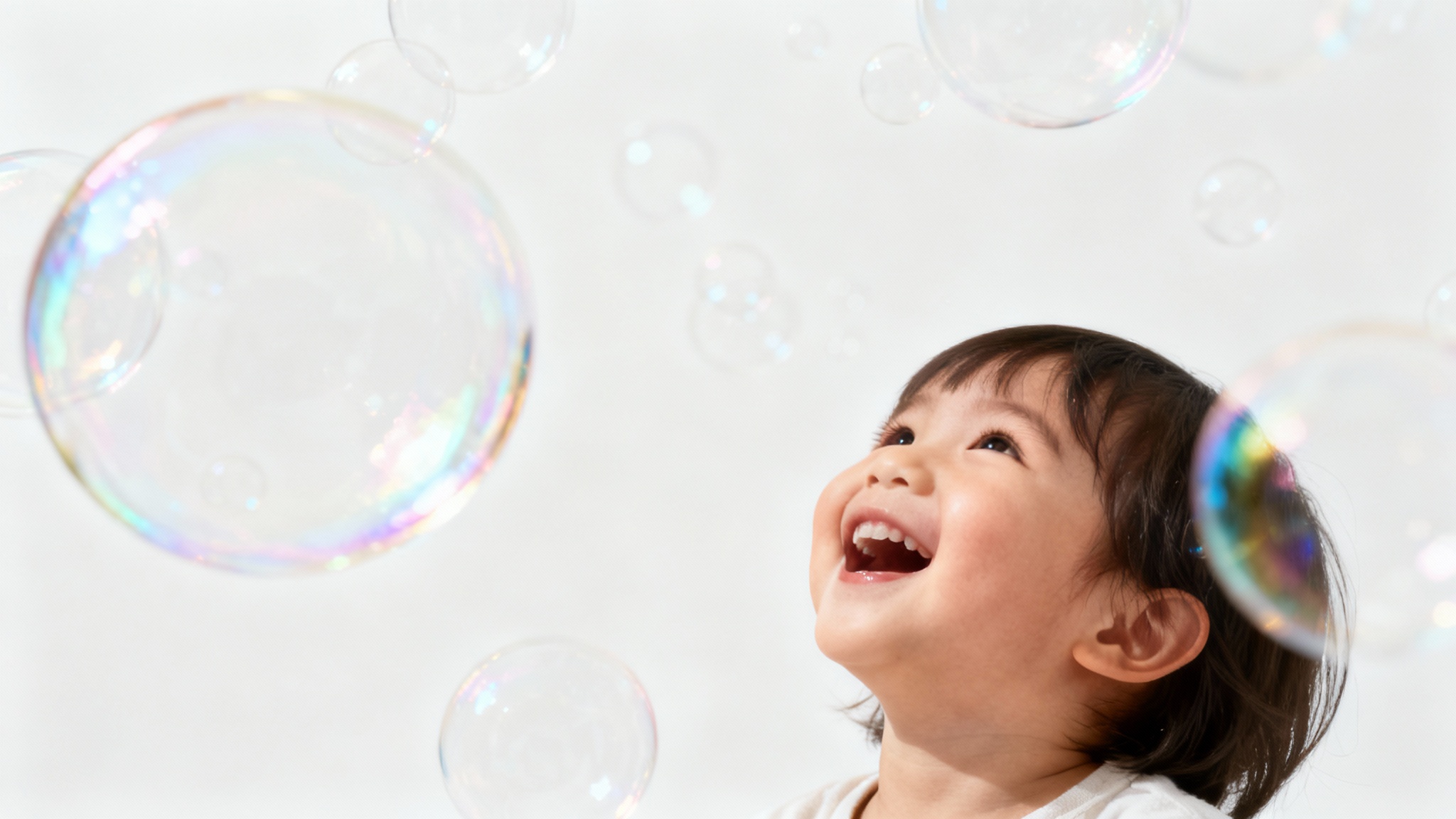 A photorealistic image of a happy child surrounded by a magical overlay of shimmering, multi-colored soap bubbles against a plain white background.