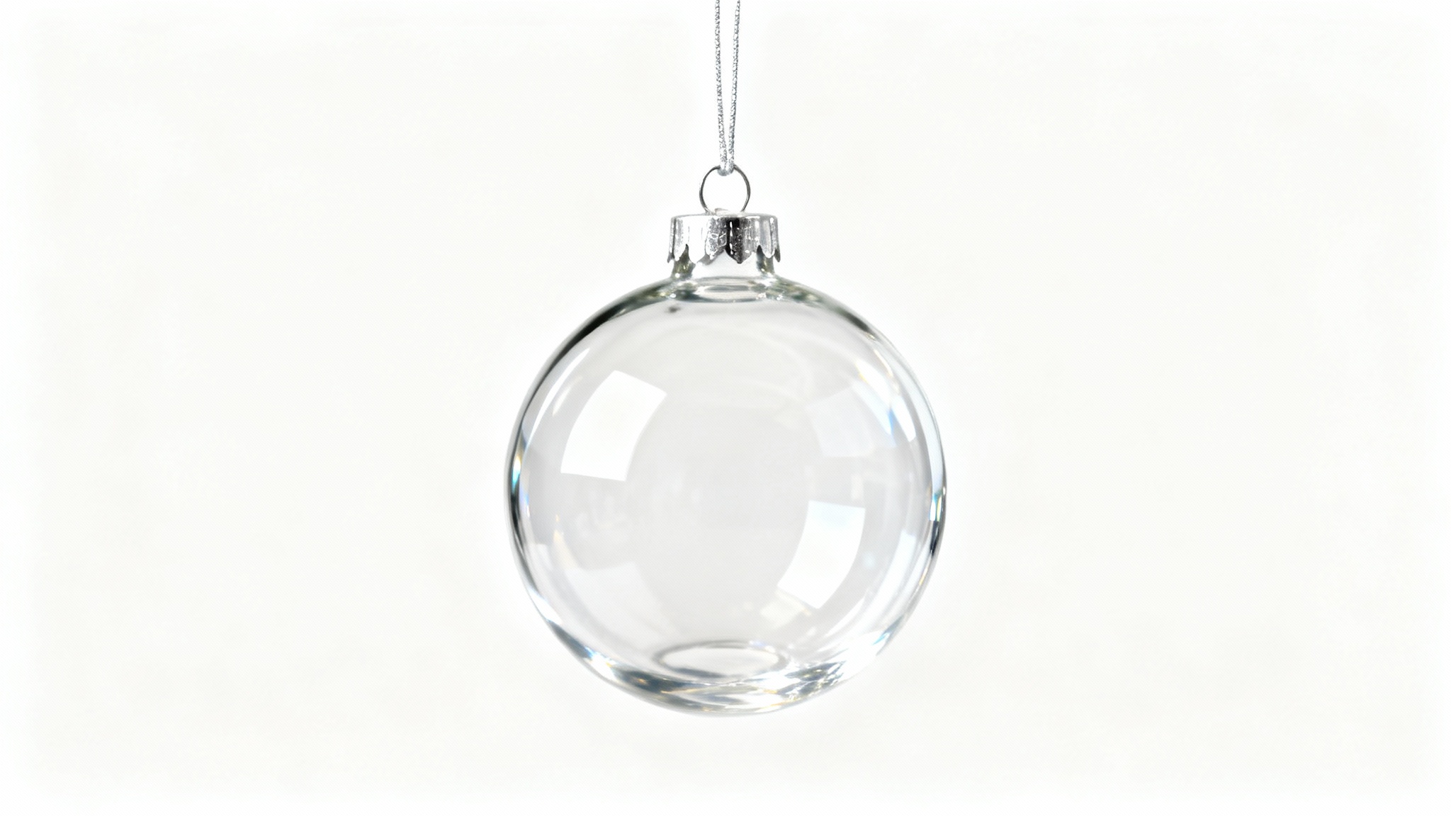 A close-up product photo of a single, perfectly clear, spherical glass Christmas ornament hanging against a solid white background, showcasing its minimalist and elegant design.