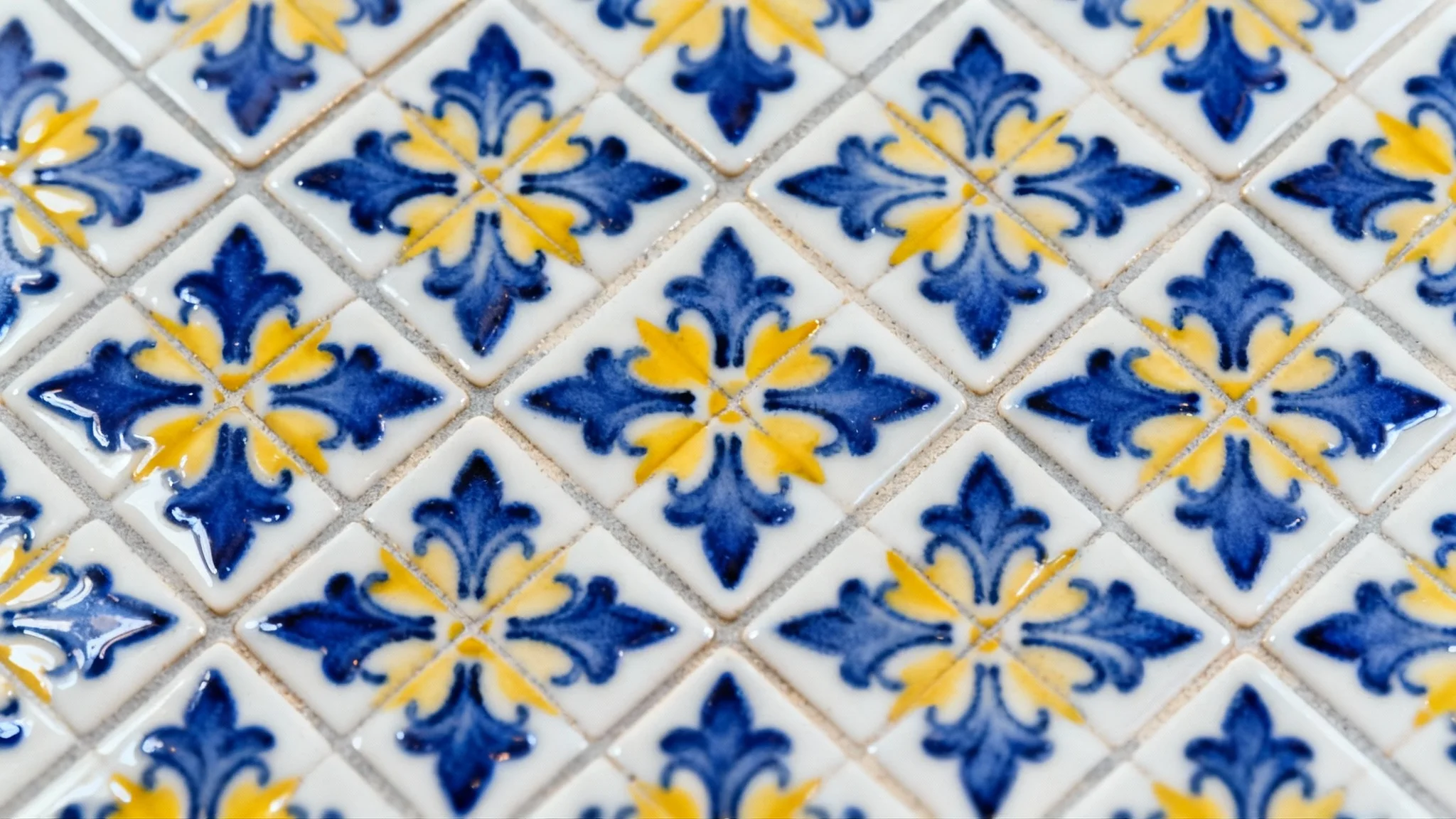 A close-up, top-down view of an elegant, seamless tile pattern with blue and yellow floral motifs on a white background, reminiscent of Portuguese azulejo tiles.