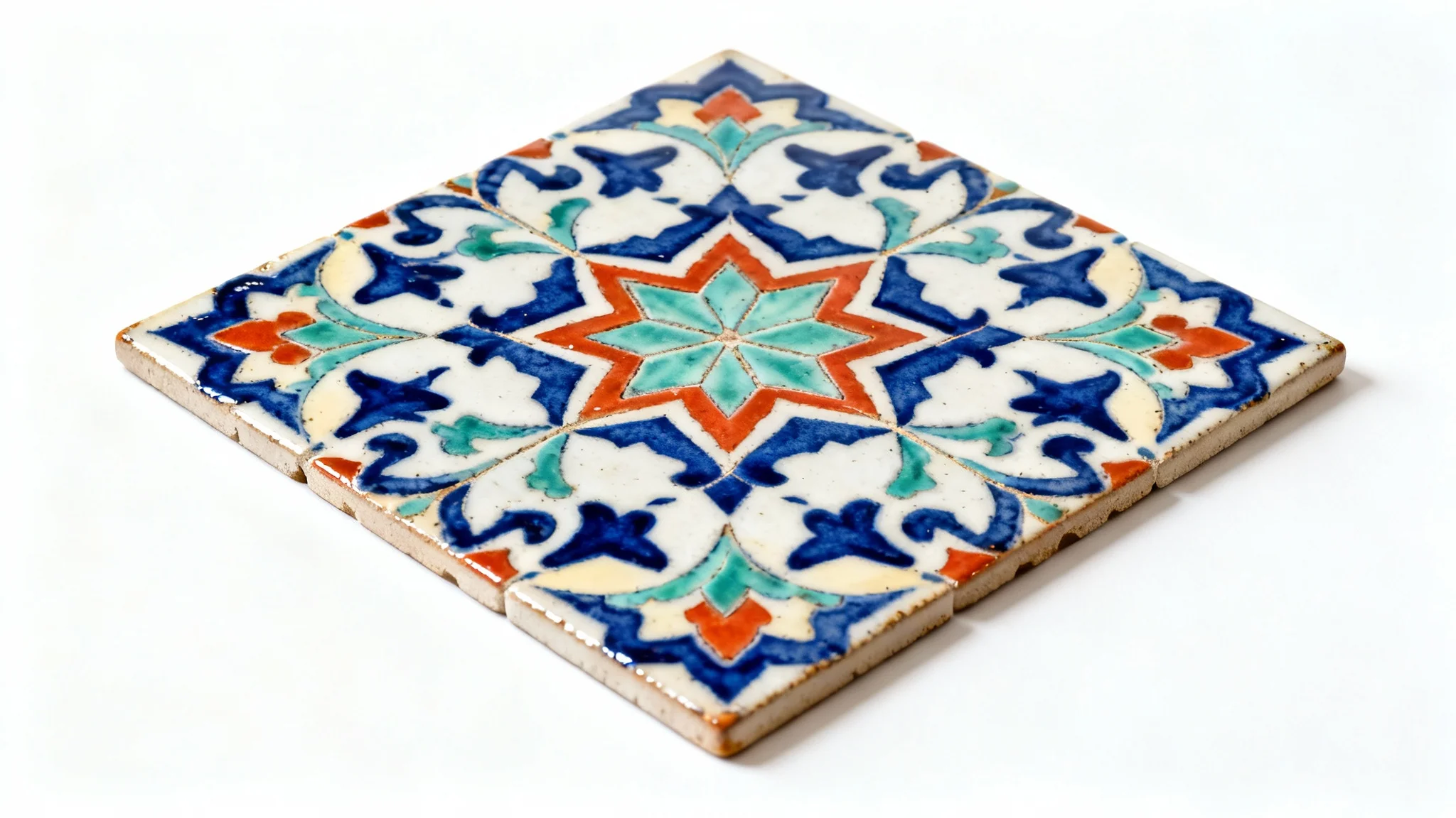 A photorealistic mockup of a square swatch of intricate Mediterranean-style geometric tiles in blue, green, and orange, viewed from above on a clean white background.
