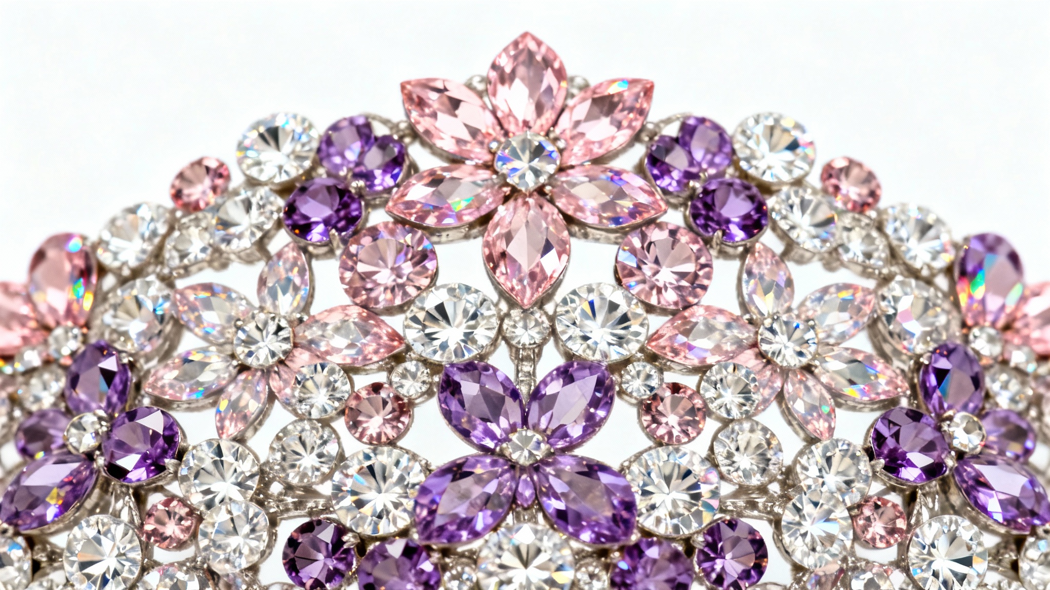 An extreme close-up of a beautiful floral pattern created with sparkling pink, purple, and clear rhinestones, set against a plain white background.