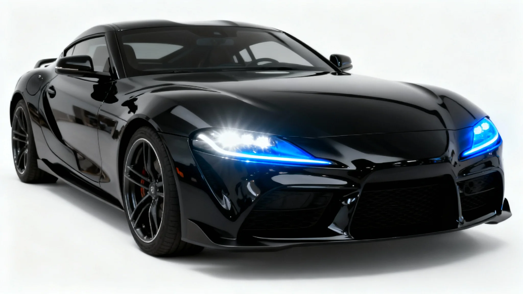 A studio photograph of the front of a modern black sports car, with one headlight shining white and the other shining a bright electric blue to show a headlight color change feature.