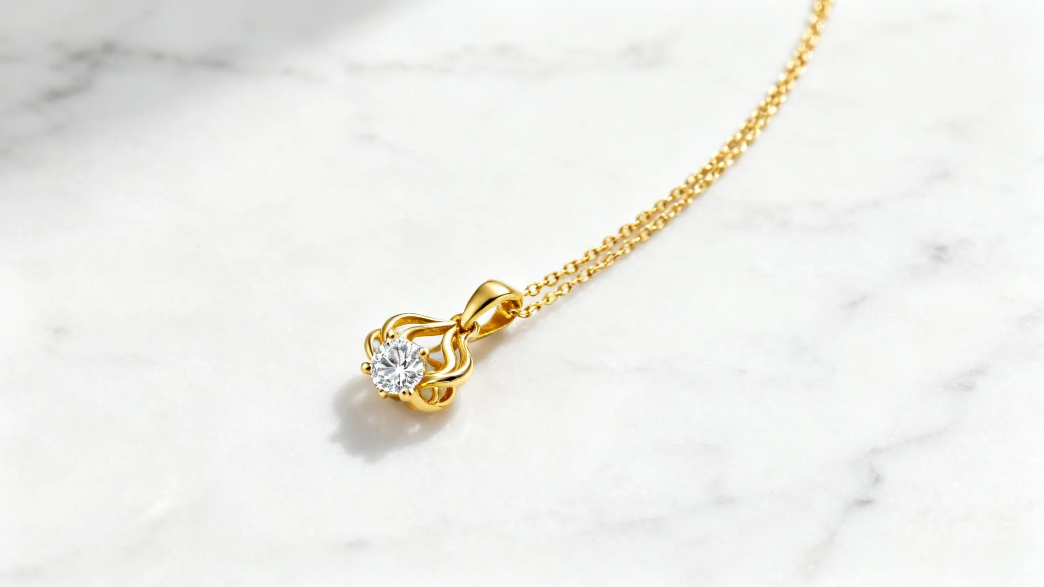 A professionally shot photograph of a delicate gold necklace with a diamond pendant, displayed elegantly on a white marble background.