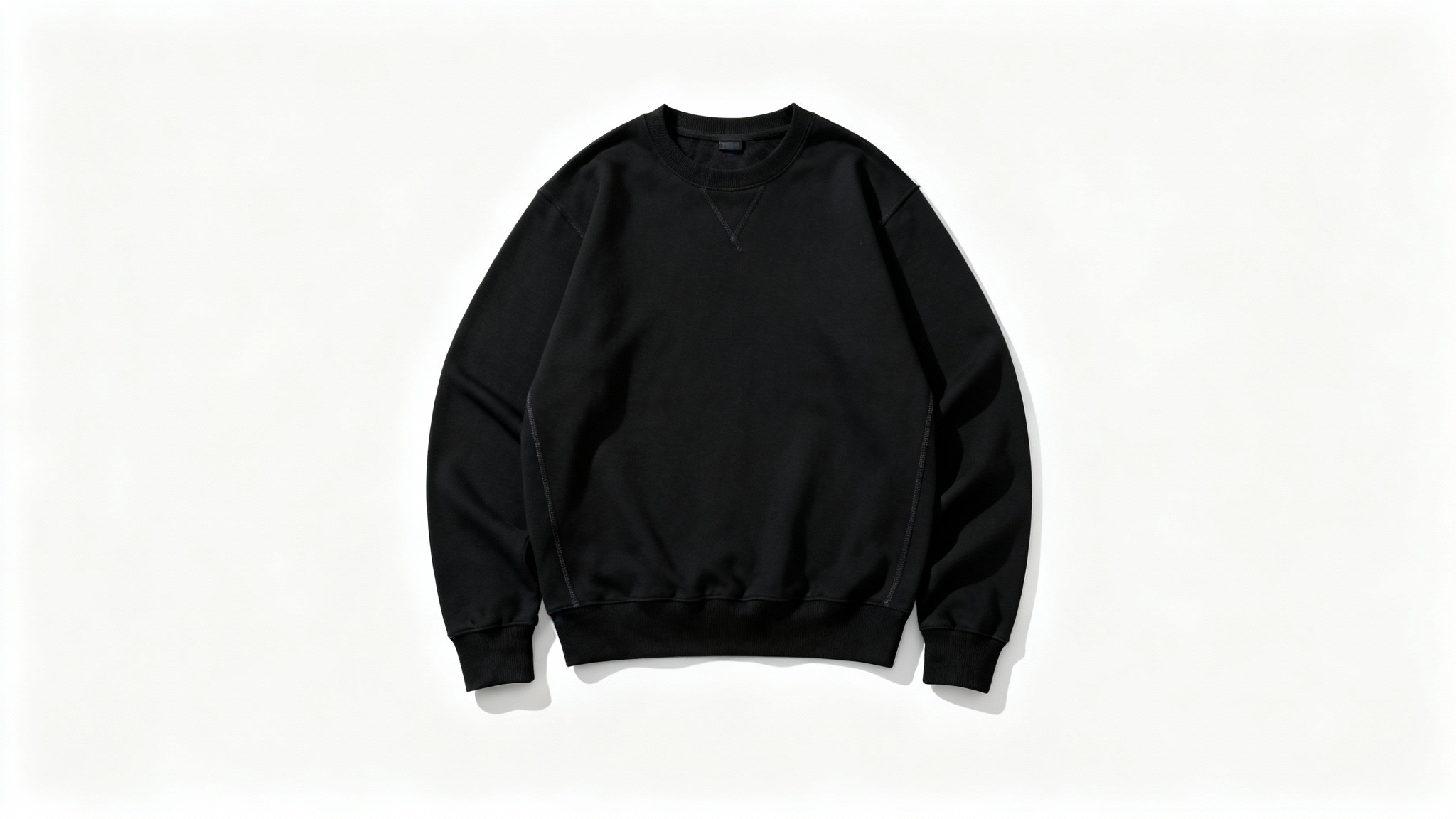 A high-quality mockup of a black crewneck sweatshirt laid flat against a solid white background, shot from above to clearly display its texture and shape.
