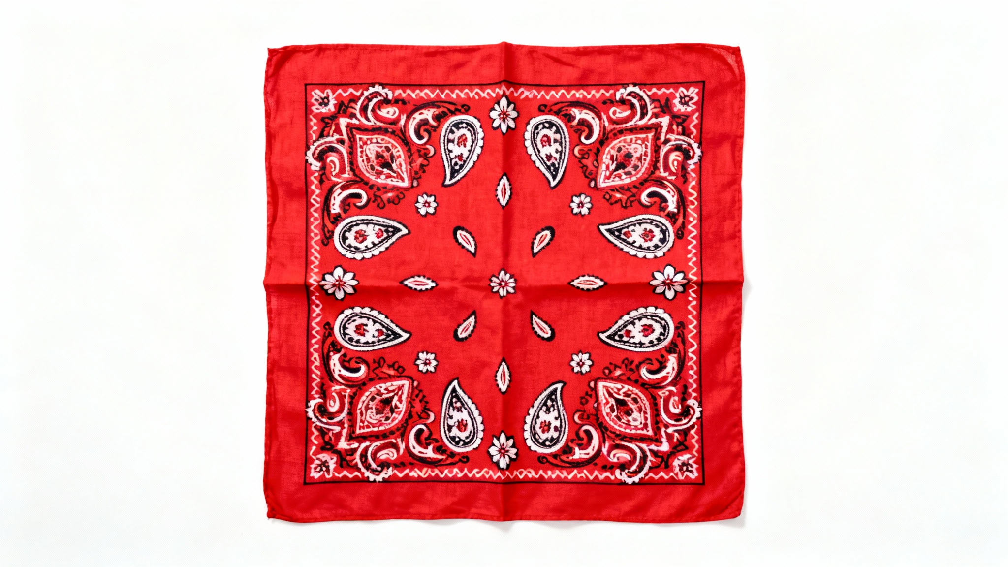 A flat lay image of a folded red bandana showcasing a classic, intricate white and black paisley pattern, set against a plain white background.