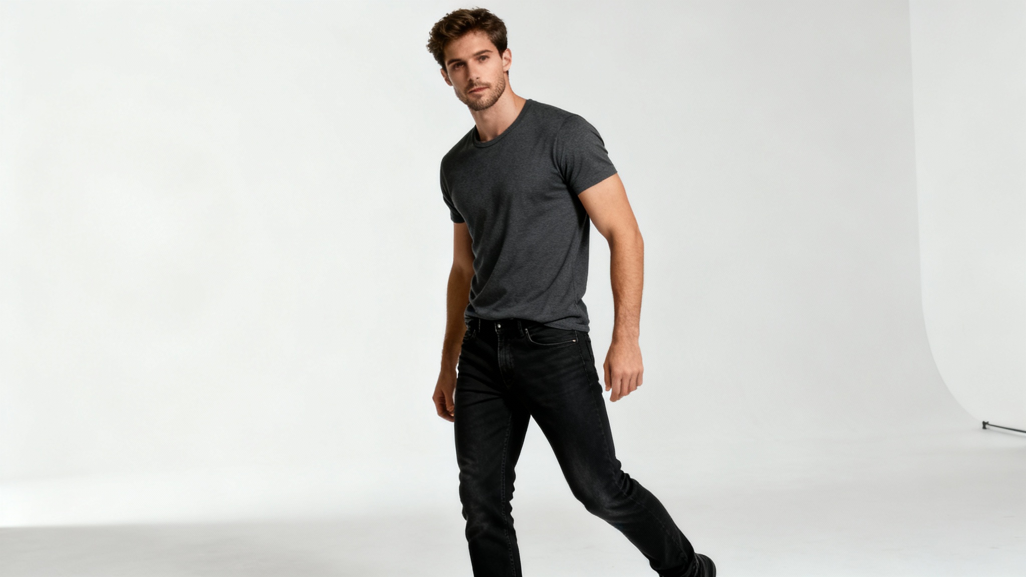 A photorealistic image of a man in casual clothing striking a confident and powerful full-body pose in a professional photo studio with a white background.