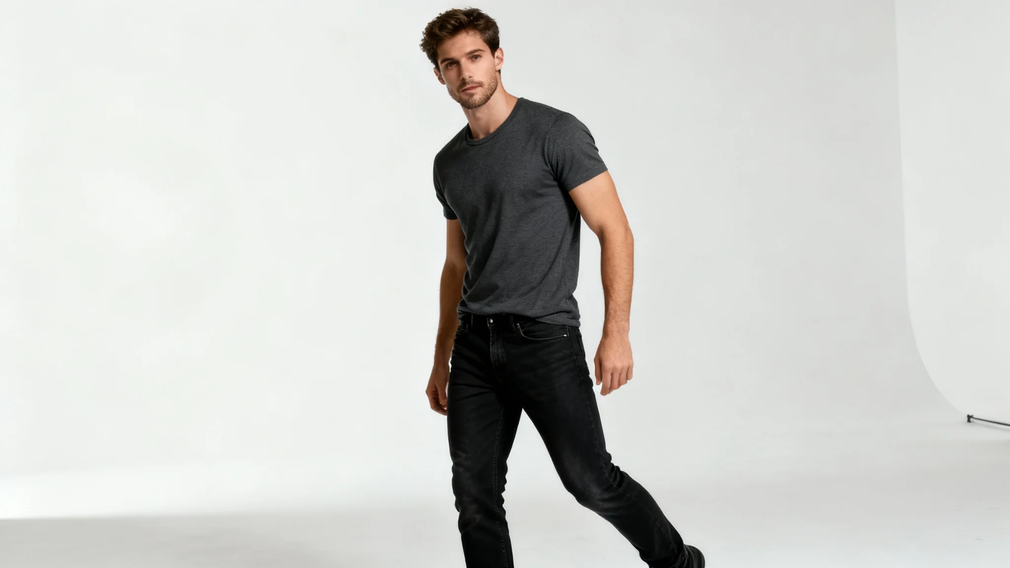 A photorealistic image of a man in casual clothing striking a confident and powerful full-body pose in a professional photo studio with a white background.