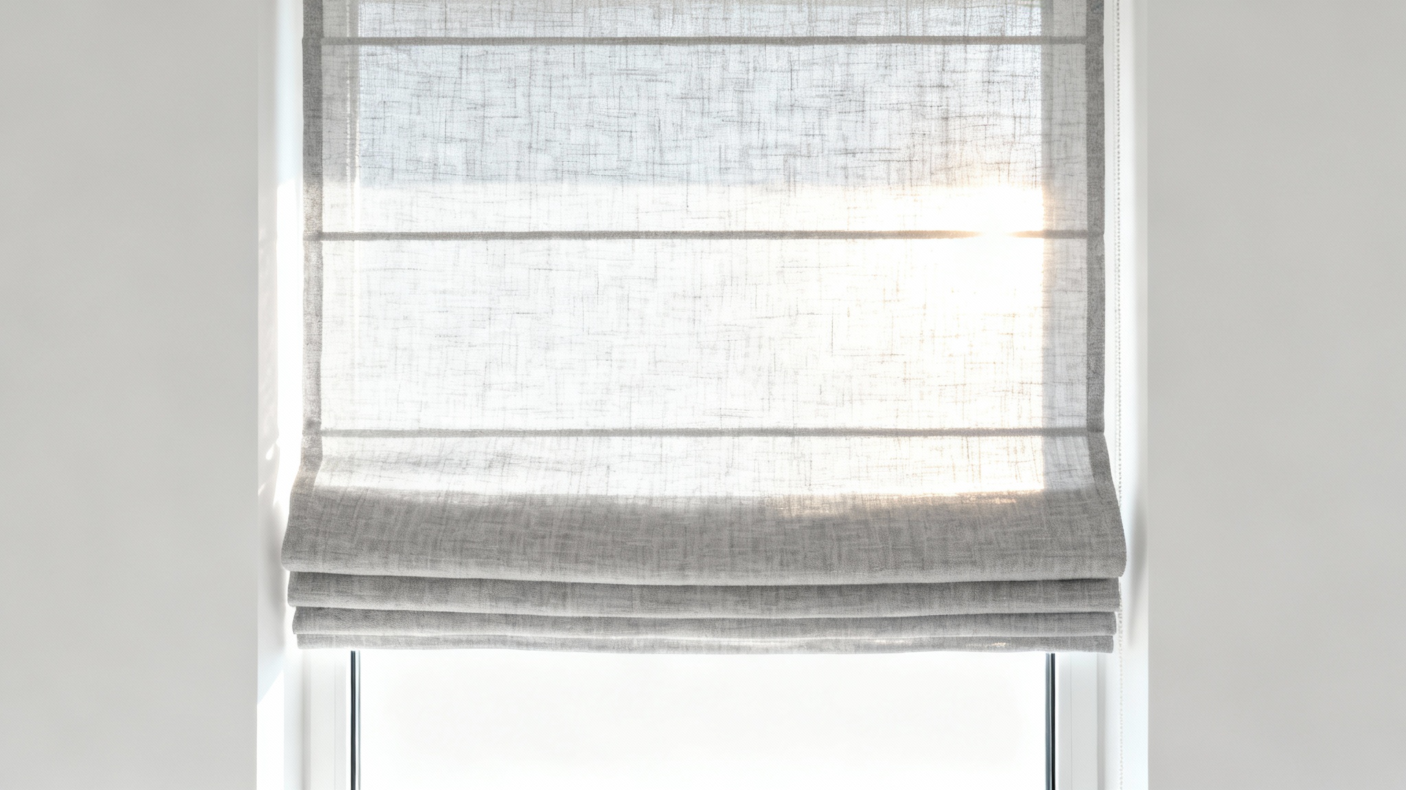 A minimalist mockup of an elegant, light-gray linen Roman shade against a white background, with soft sunlight filtering through to create a warm and serene ambiance.