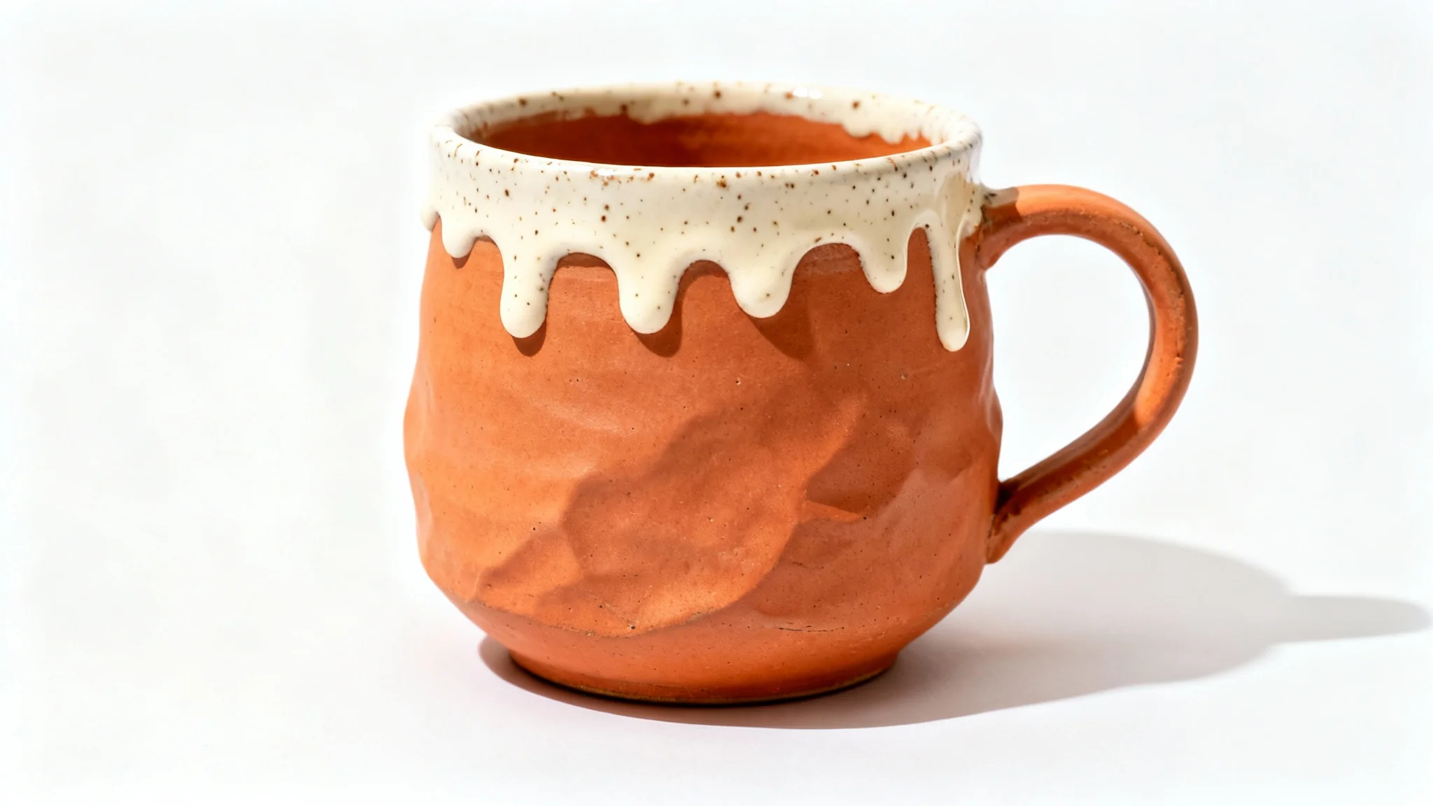 A professional product photograph of a single handmade terracotta ceramic mug with a speckled cream glaze, shot against a clean white background to be used as an Etsy product photo.