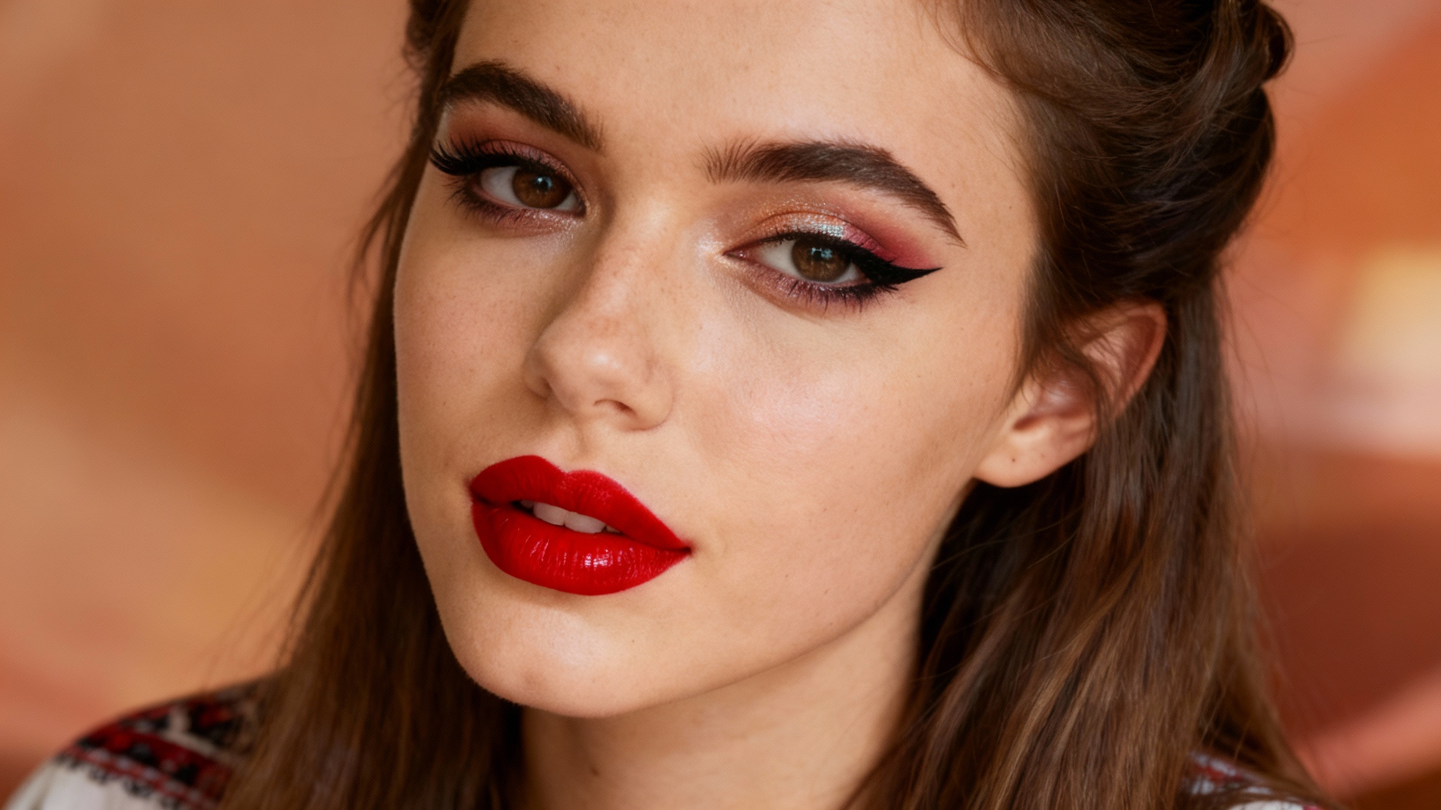 A close-up hero shot of a woman's face with flawlessly applied digital makeup, including bold eyeliner and vibrant red lipstick, showcasing the result of a beauty application.