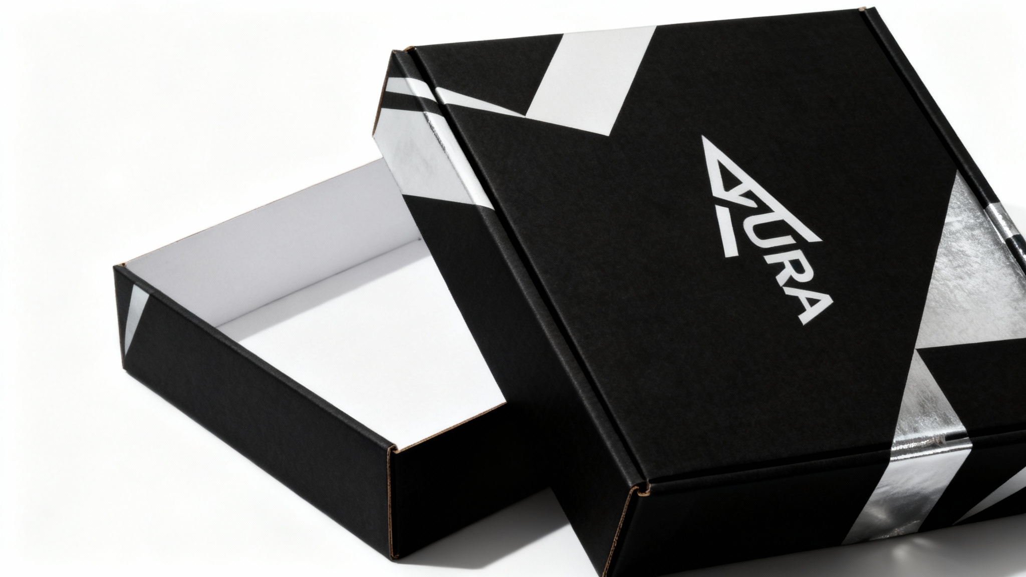 A high-quality photograph of a custom-designed mailer box, showing the final product. The box is modern, black and white with silver accents, and features the logo 'AURA'.