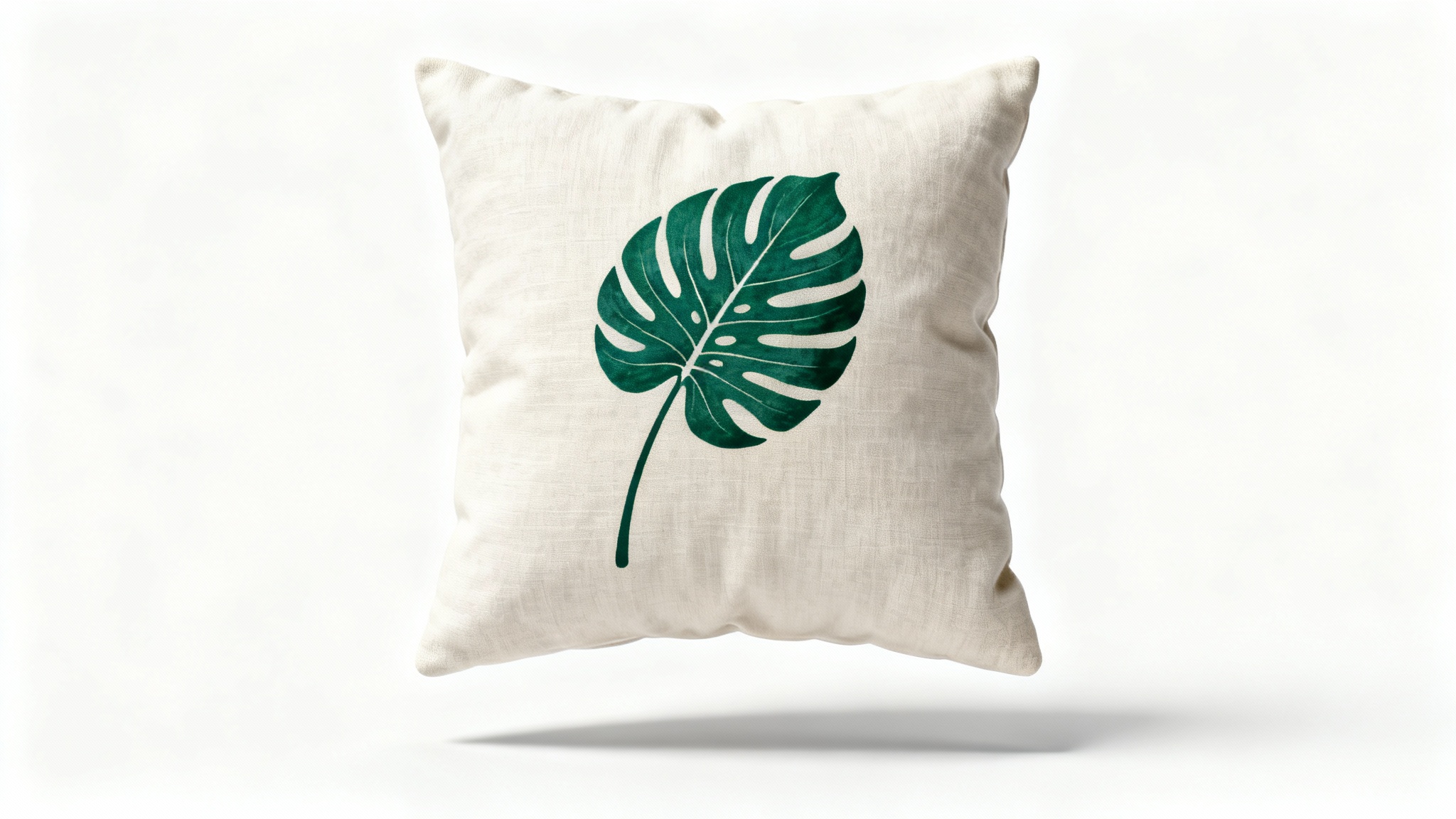 A photorealistic mockup of a square, plush throw pillow with a modern green monstera leaf design, set against a clean white background.