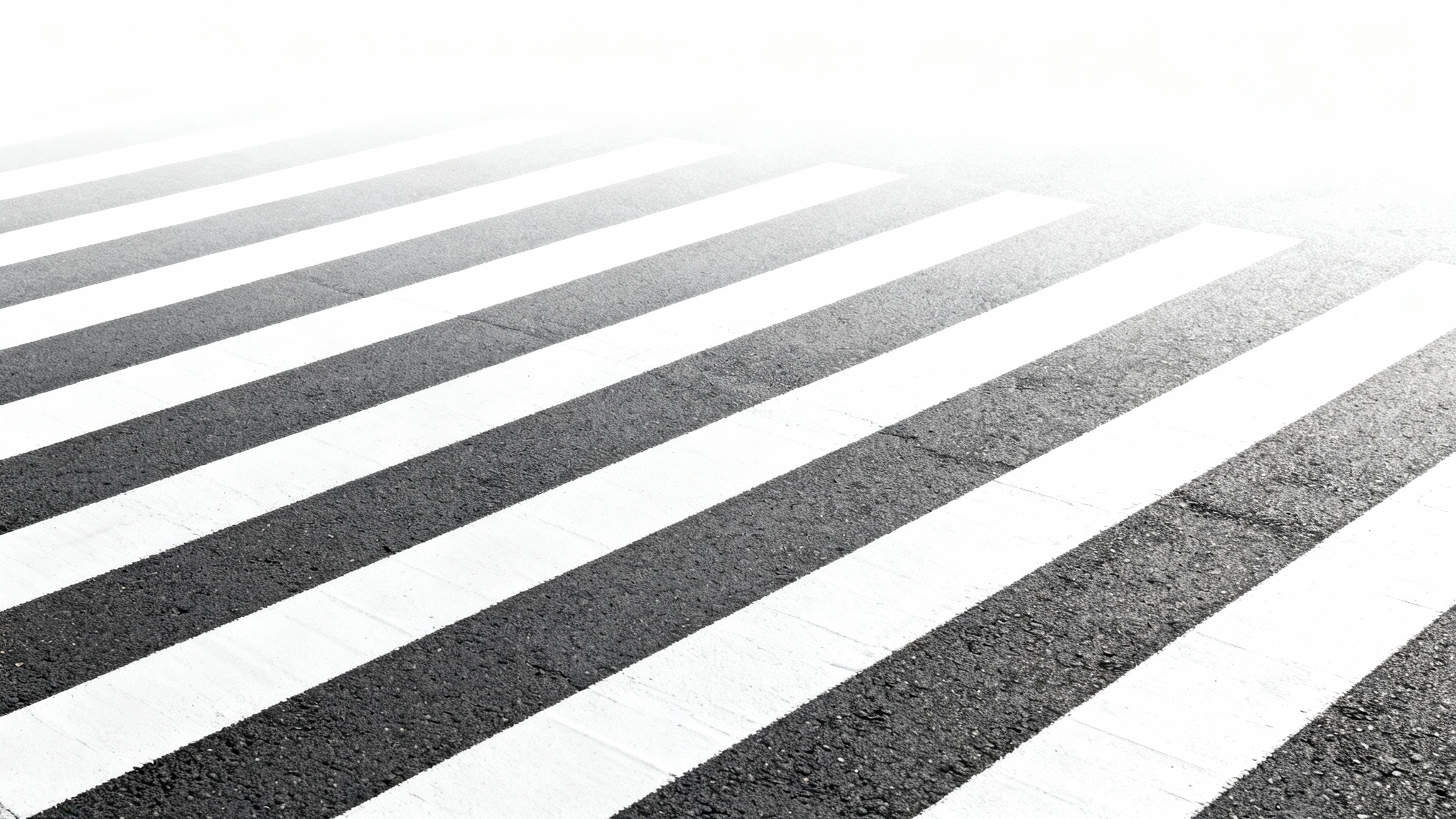 A clean, modern top-down view of a white pedestrian crosswalk on a dark asphalt road, isolated against a plain white background.