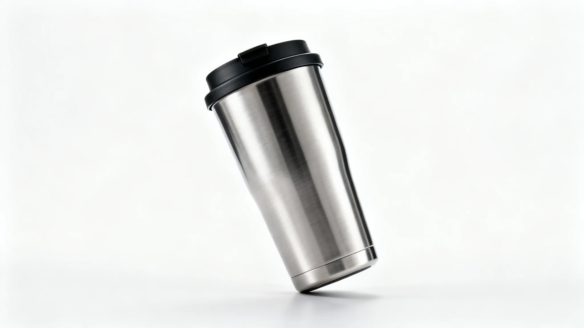 A photorealistic mockup of a modern stainless steel travel mug with a brushed finish and black lid, set against a clean, white background in a studio lighting setup.