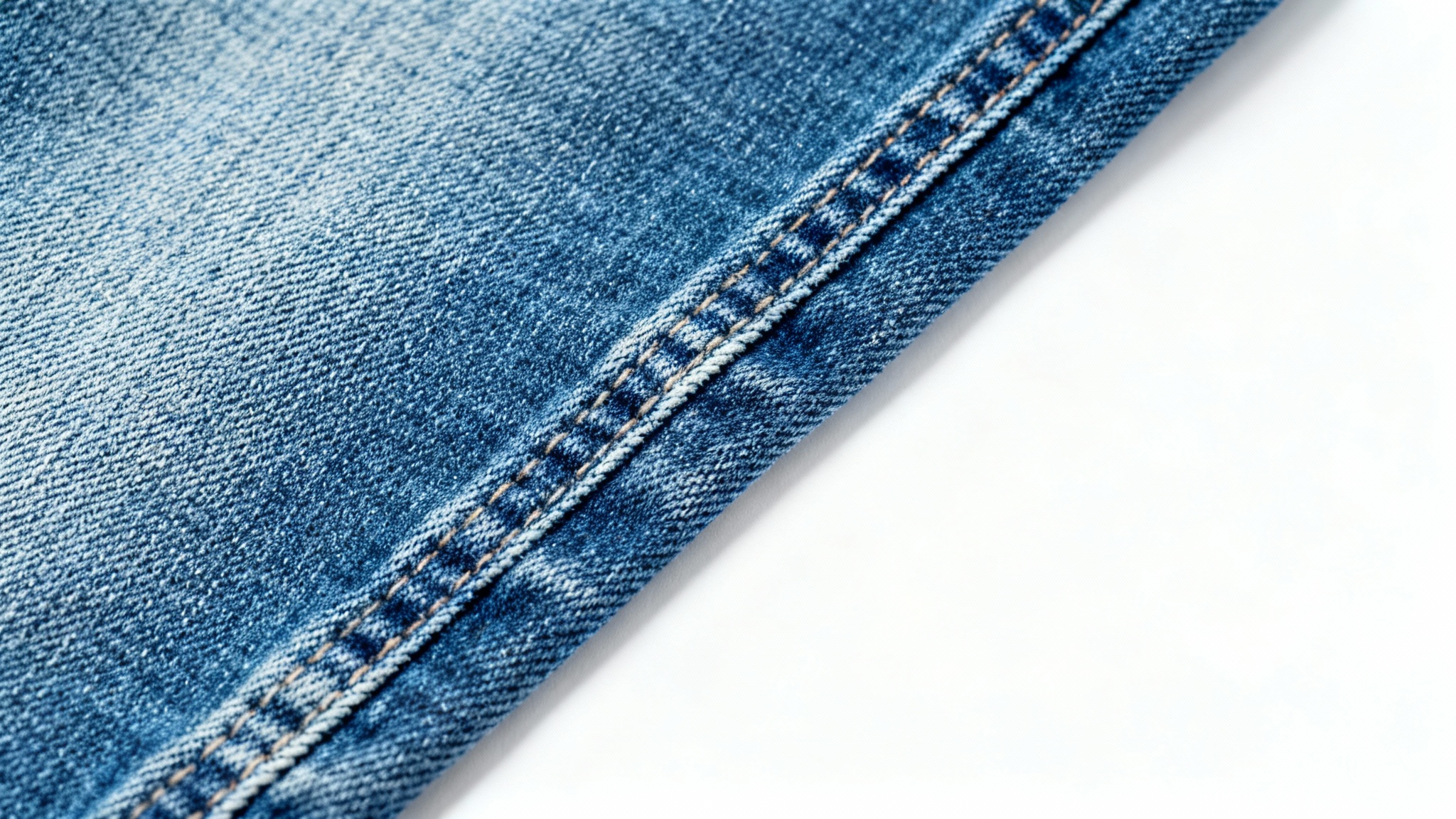 A detailed, top-down macro shot of a classic blue denim fabric, showcasing its intricate twill texture and weave, isolated on a plain white background.