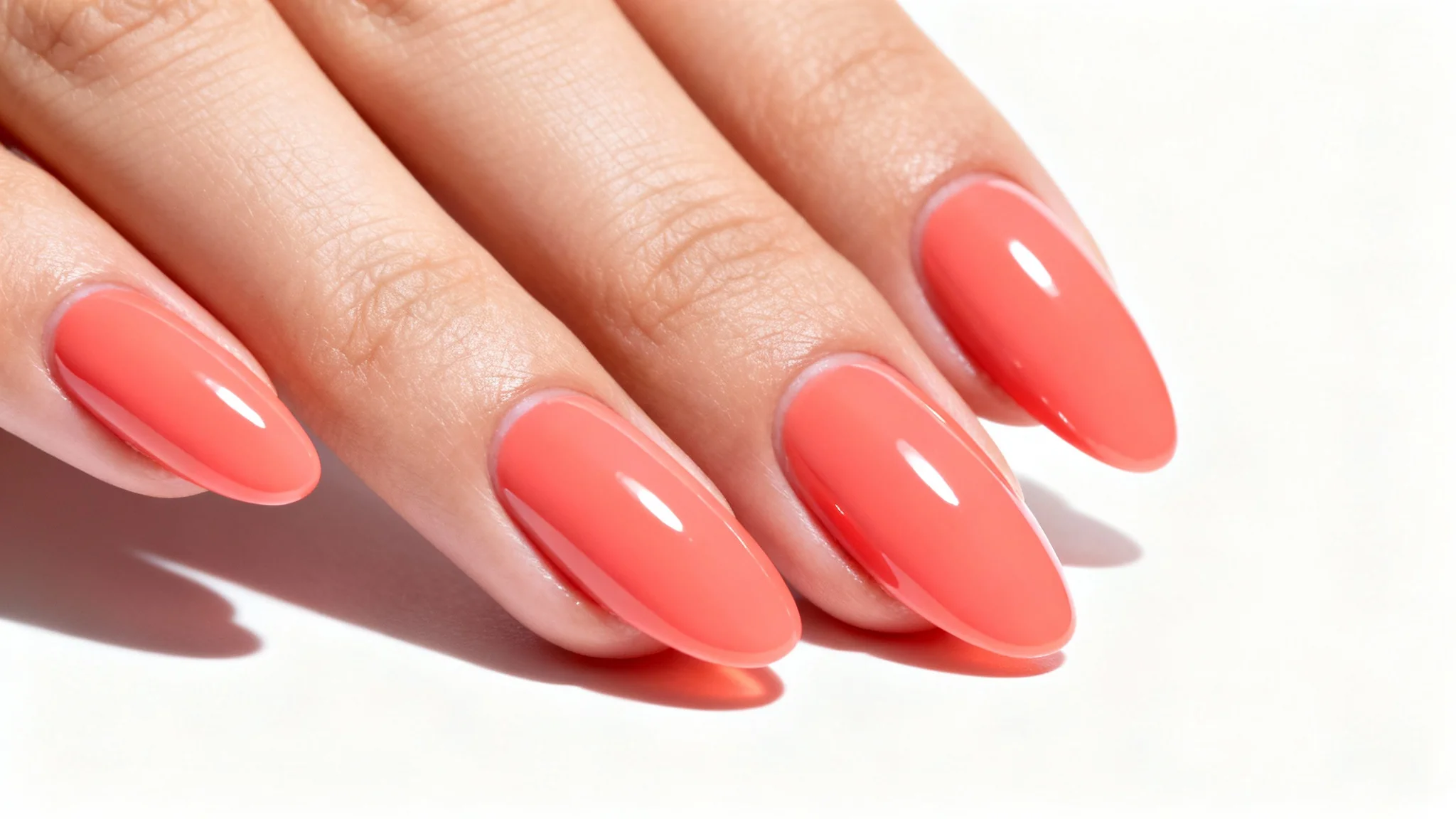 A close-up image of a woman's perfectly manicured hand showcasing a flawless, vibrant coral nail polish, representing a virtual nail polish try-on application.