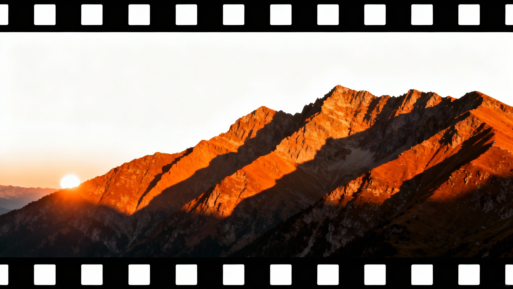 A cinematic-style image of a mountain landscape at sunset, featuring wide black bars at the top and bottom for a widescreen effect, presented on a white background.
