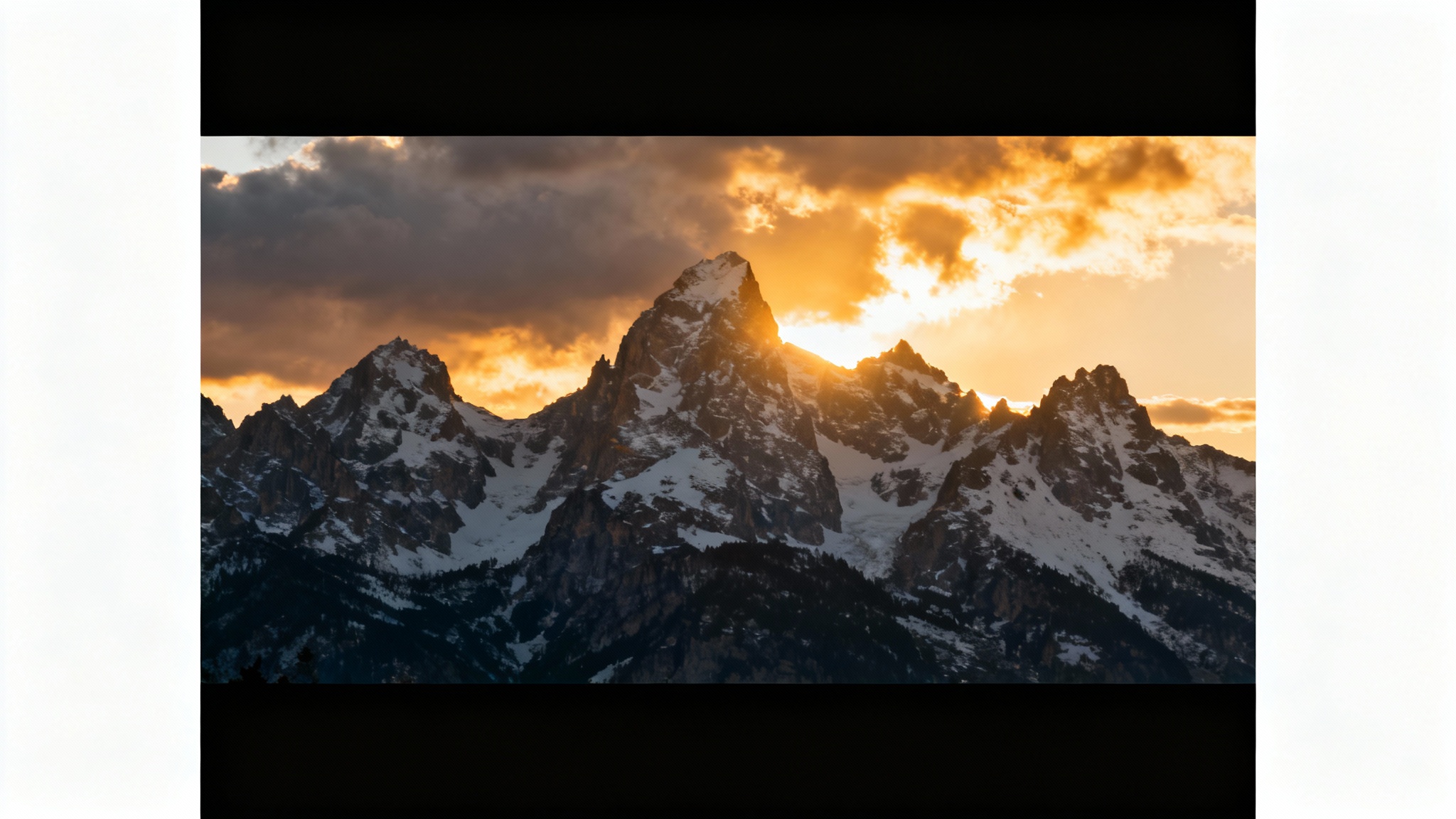 A mockup of a dramatic mountain landscape photo with wide, cinematic black bars at the top and bottom, presented against a clean white background to showcase the cinematic effect.